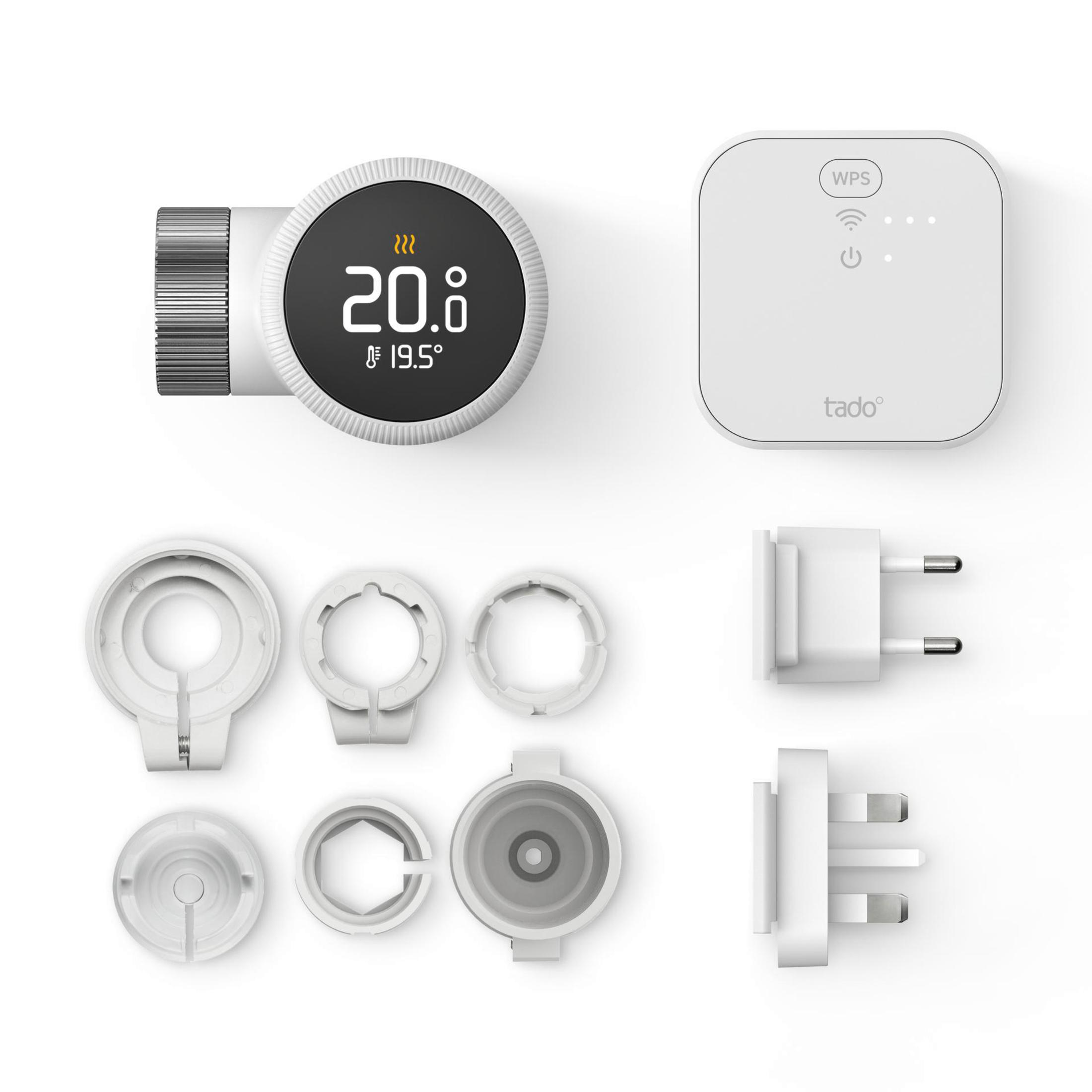 Various white smart home devices and accessories laid out on a white surface.