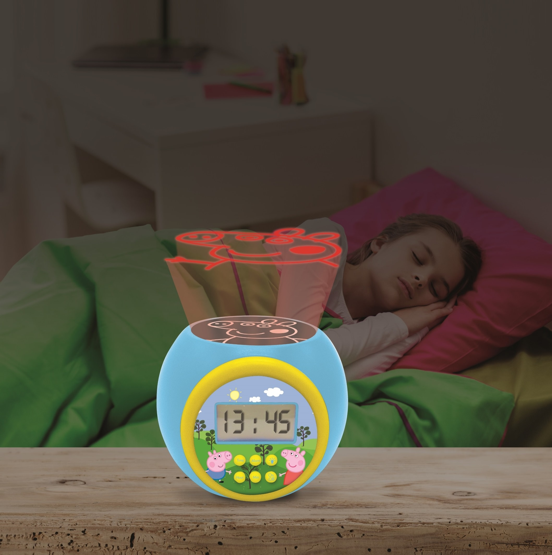 Un bambino dorme vicino a una sveglia blu che proietta un'immagine di Peppa Pig sul soffitto. Biancheria da letto verde e rosa.