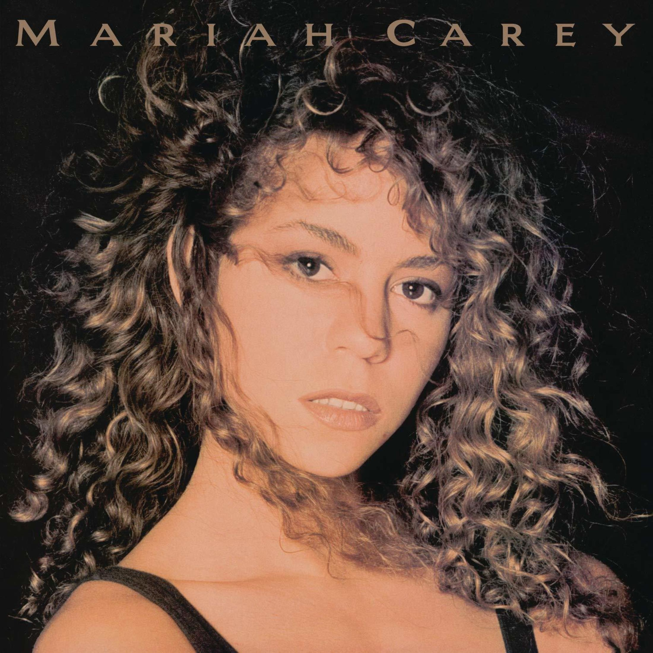 Albumhoes met een close-up portret van Mariah Carey, met krullend haar.