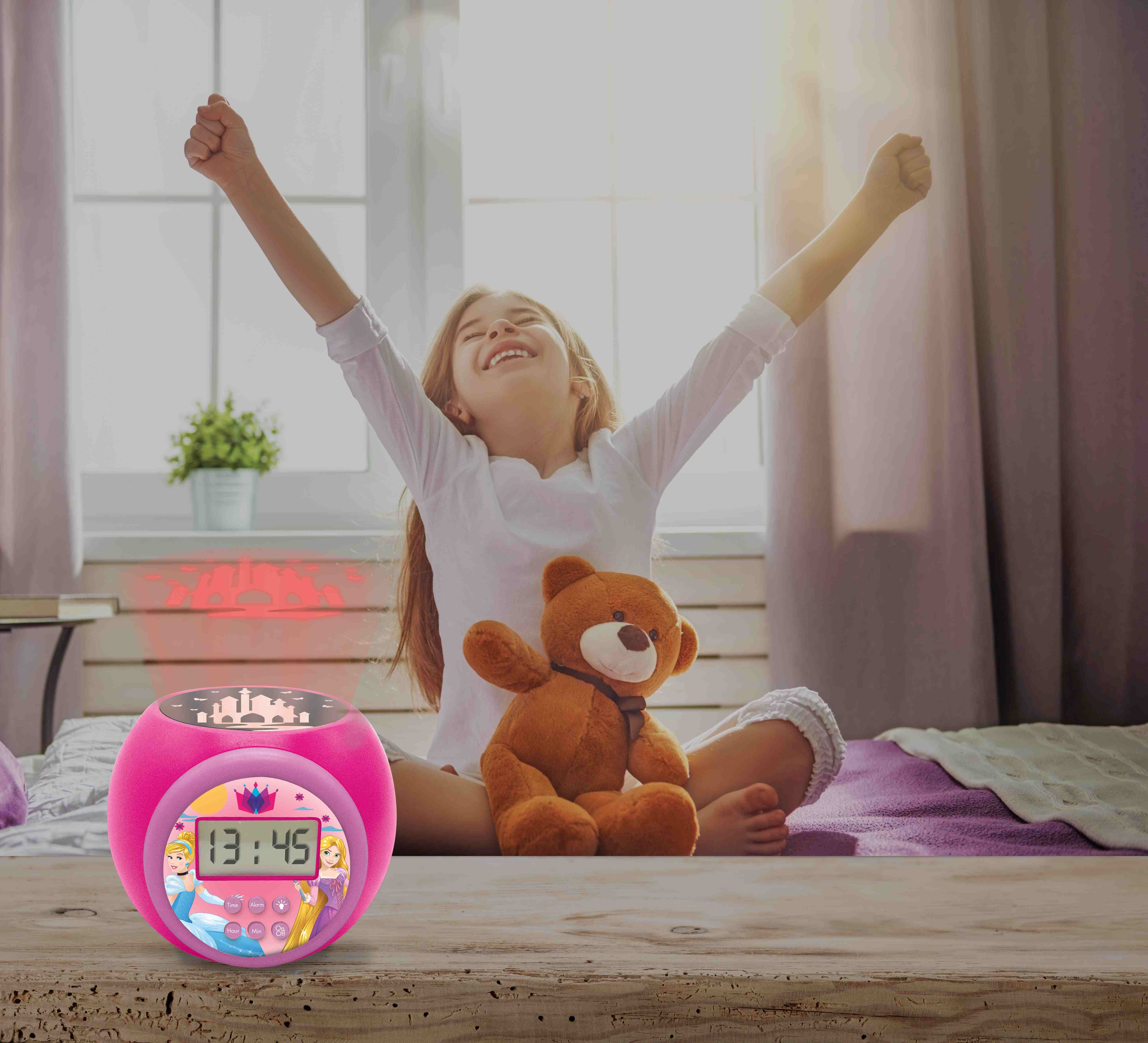 Bambina sul letto con le braccia in alto, sveglia rosa principessa con personaggi Disney.
