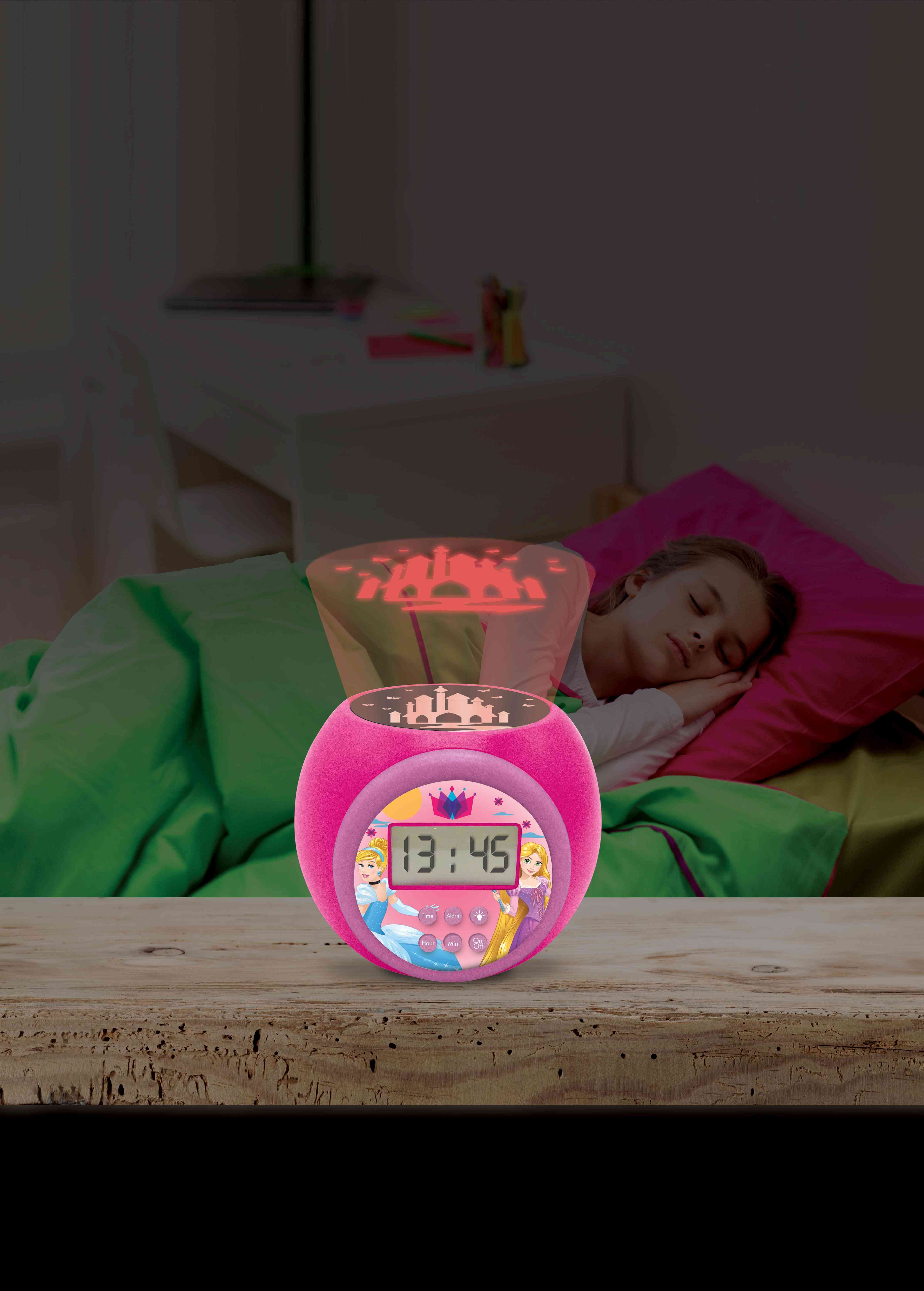 Sveglia rosa delle principesse Disney che proietta una scena di castello su un muro sopra un letto.