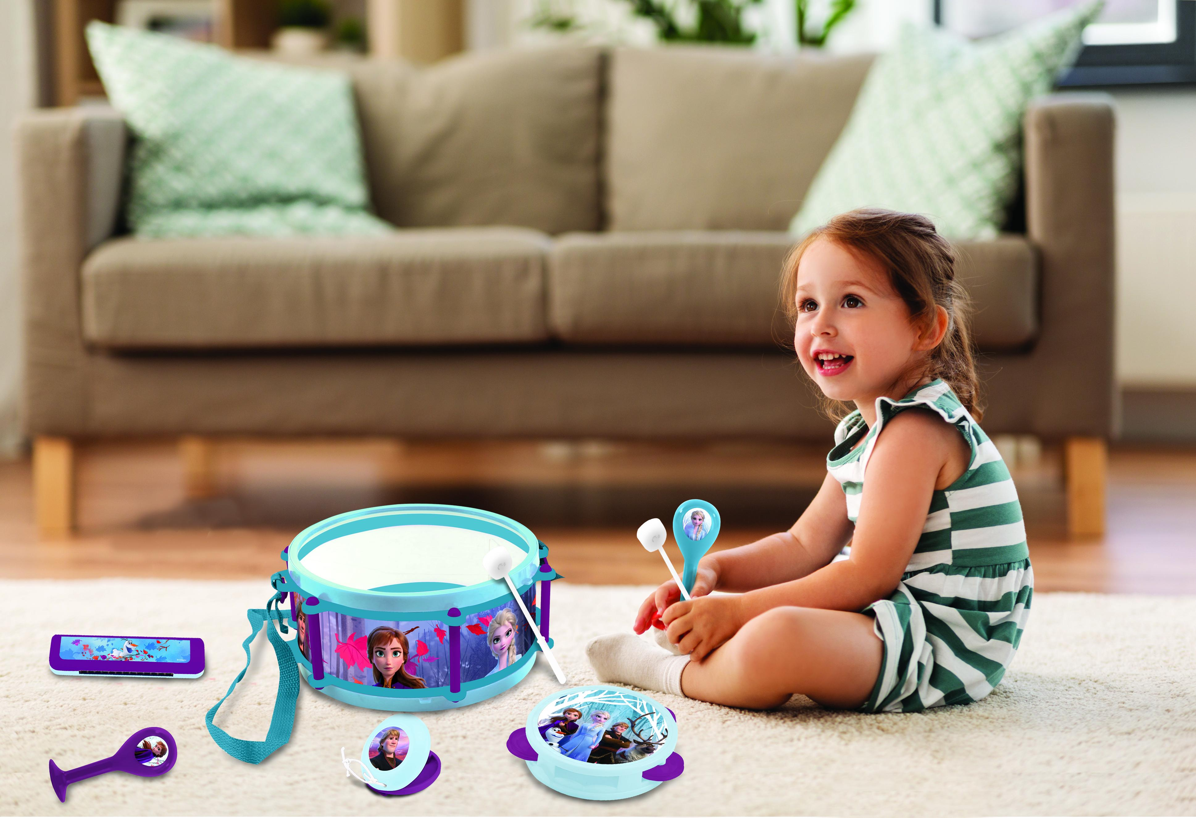 Ein junges Mädchen sitzt mit Spielzeug im Frozen-Design. Eine Trommel, ein Xylophon und Spielzeug.