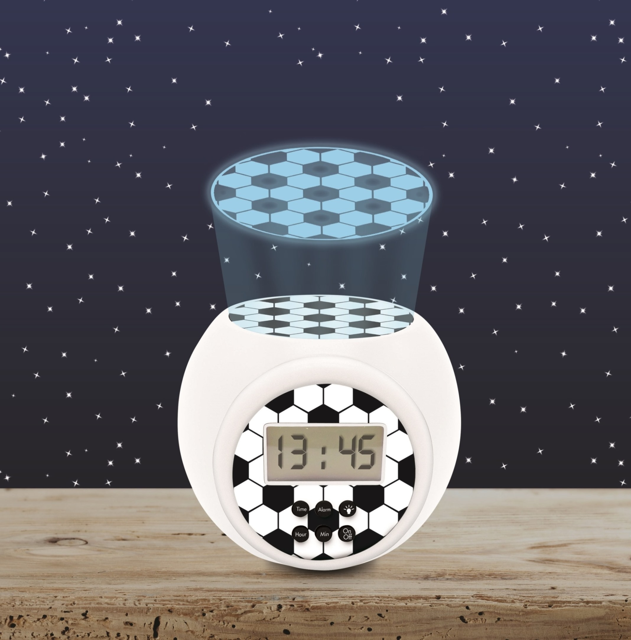 Despertador blanco con balón de fútbol con proyección de fútbol sobre superficie de madera.
