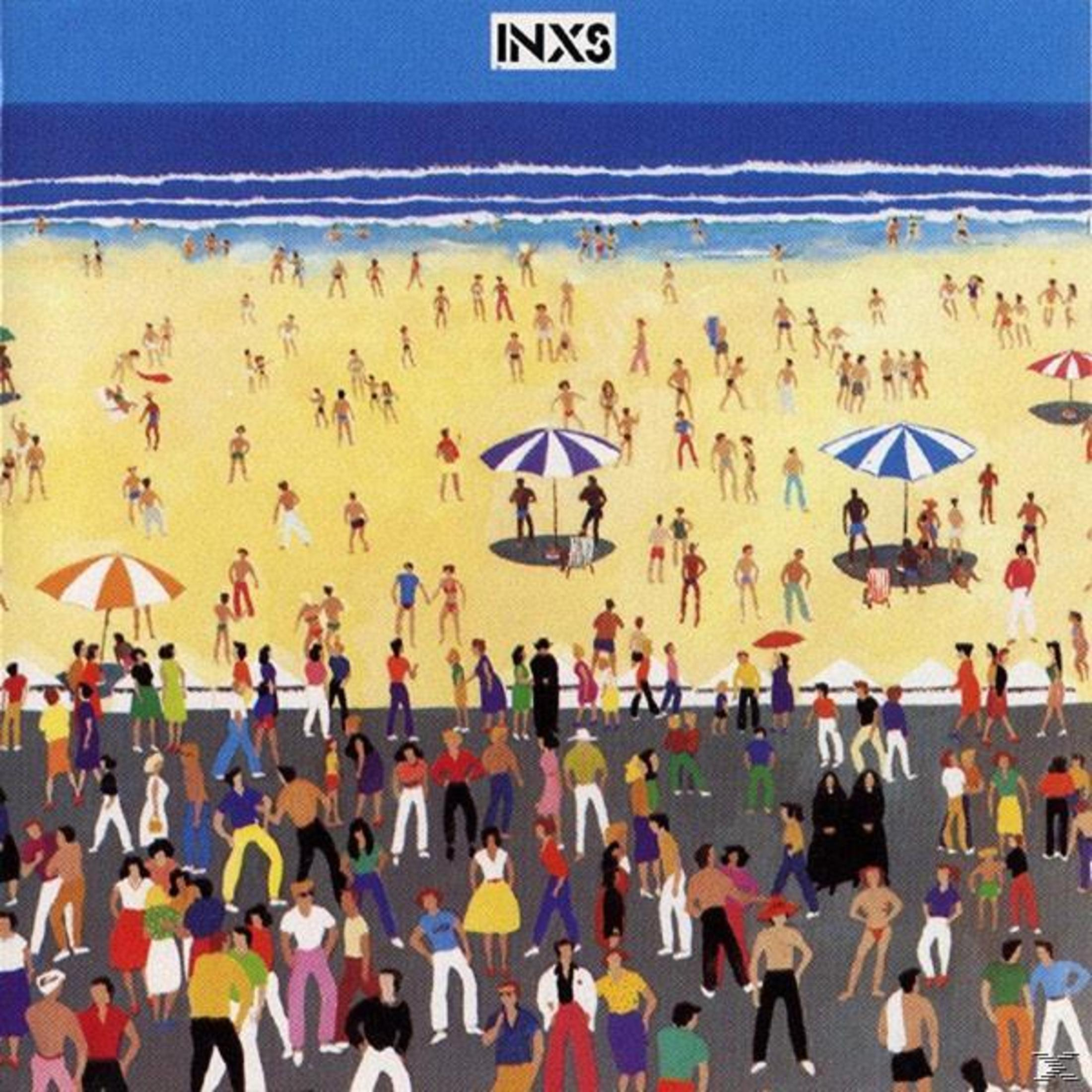 INXS albumhoes. Menigte op een strand met parasols en blauw water.