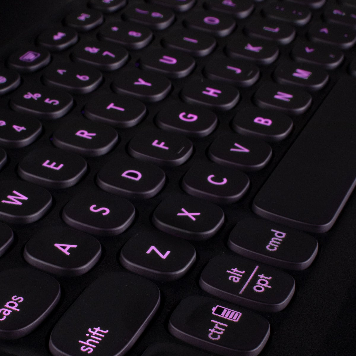 Primer plano de un teclado negro con teclas moradas brillantes, mostrando letras, números y teclas de función.