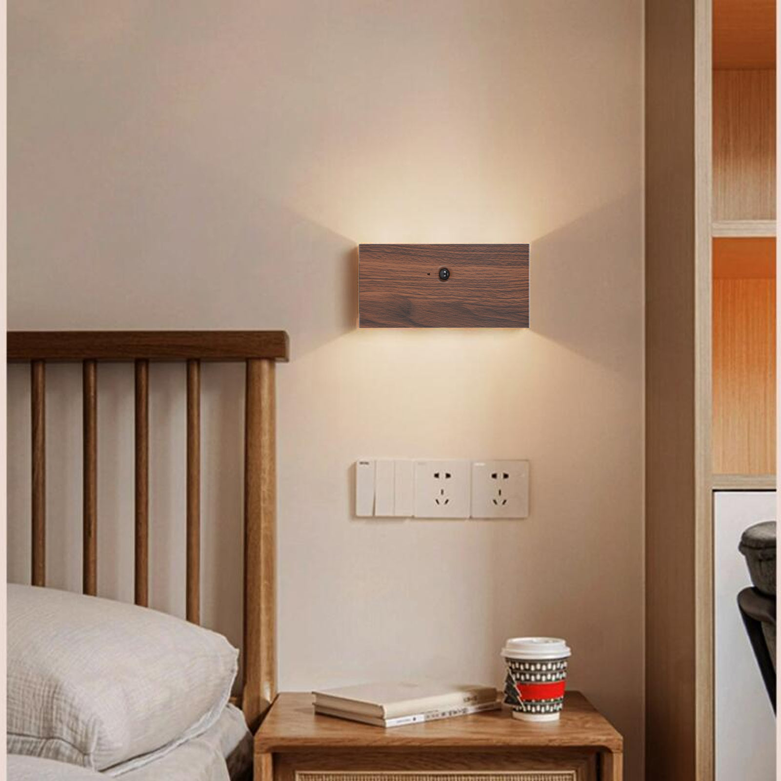 Eine Wandlampe aus Holz mit dunkler Holzfront und Steckdosen darunter an einer hellen Wand.