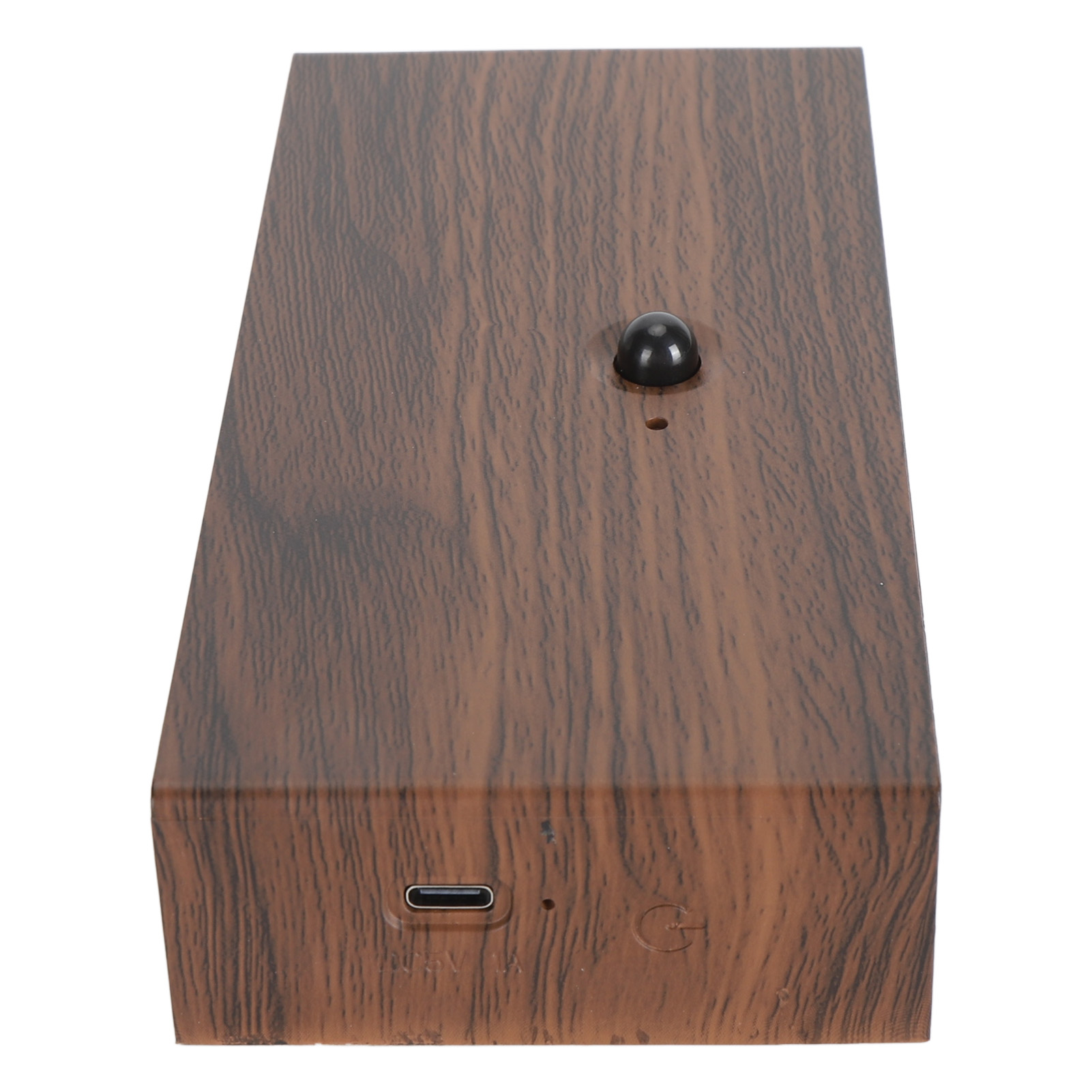 Holzkiste mit einem schwarzen Knopf oben und einem USB-Anschluss. Oberfläche mit Holzmaserung.