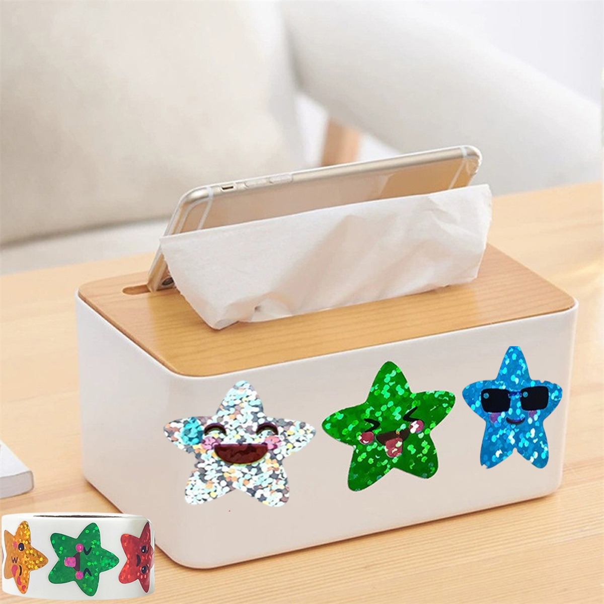 Eine Taschentuchbox mit Smartphone. Drei Sternaufkleber auf der Box. Eine Rolle Aufkleber in der linken unteren Ecke.