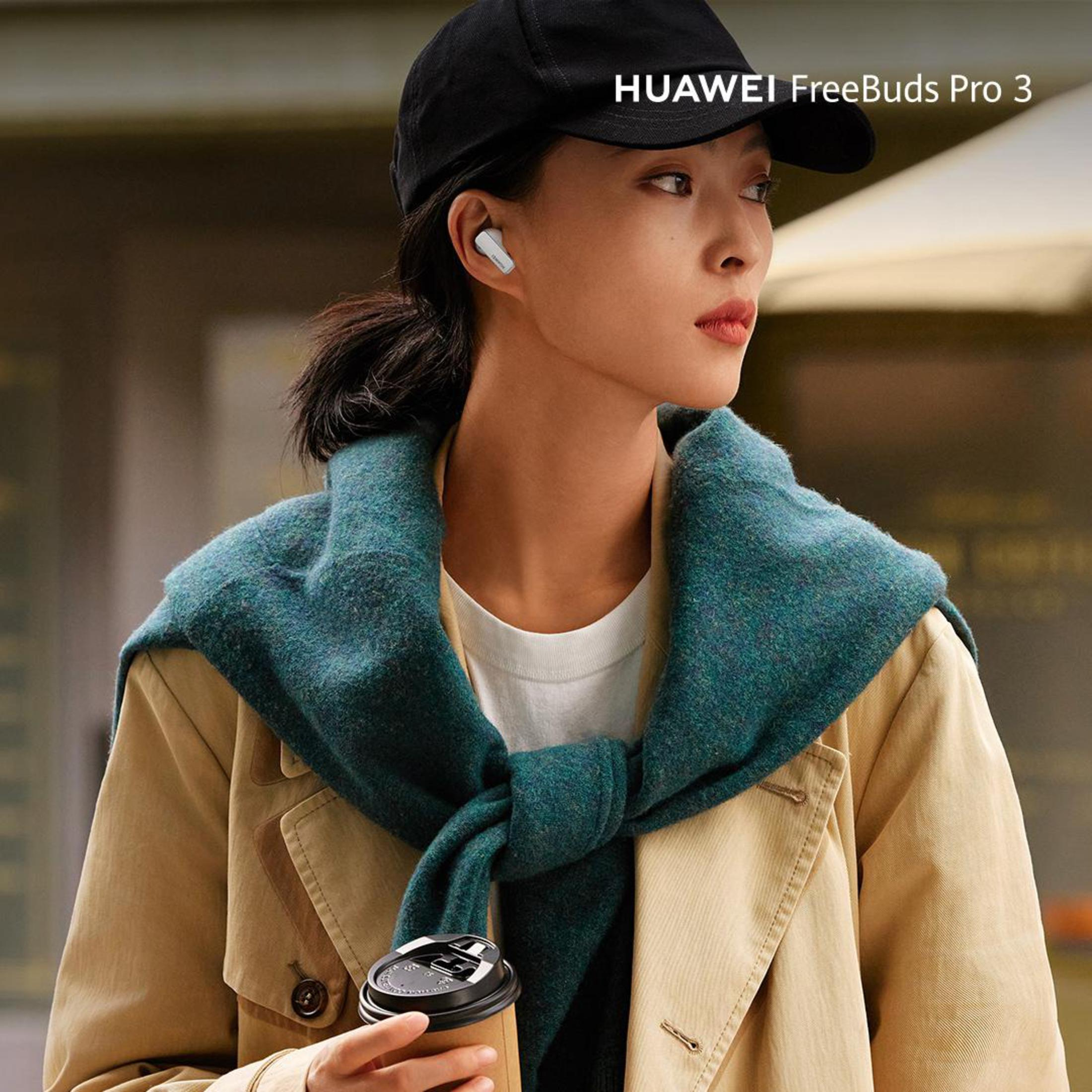 Kobieta w czapce i płaszczu z wkładkami dousznymi, trzymająca filiżankę kawy.