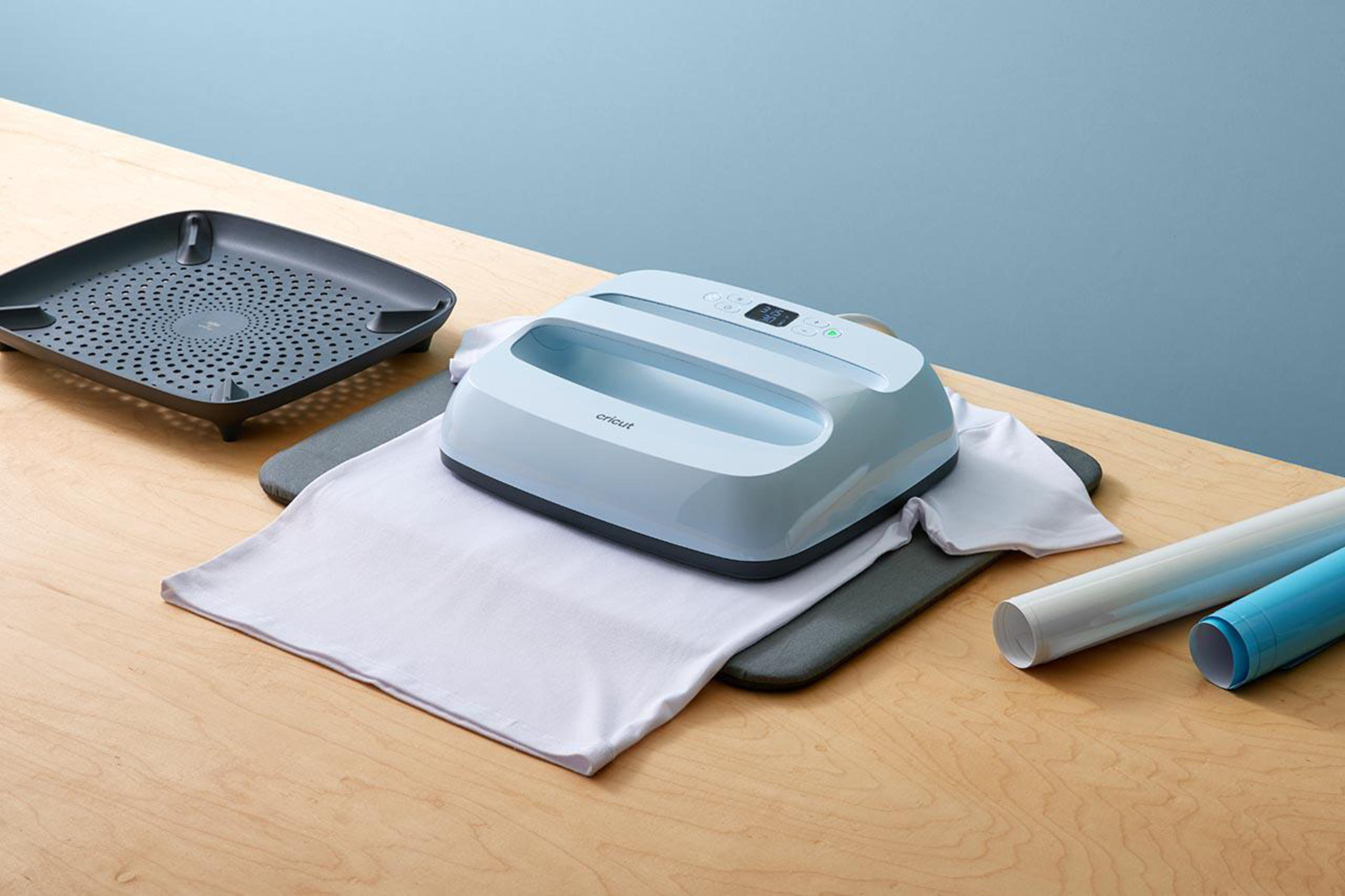 Una pressa a caldo Cricut azzurra su una maglietta bianca con accessori.