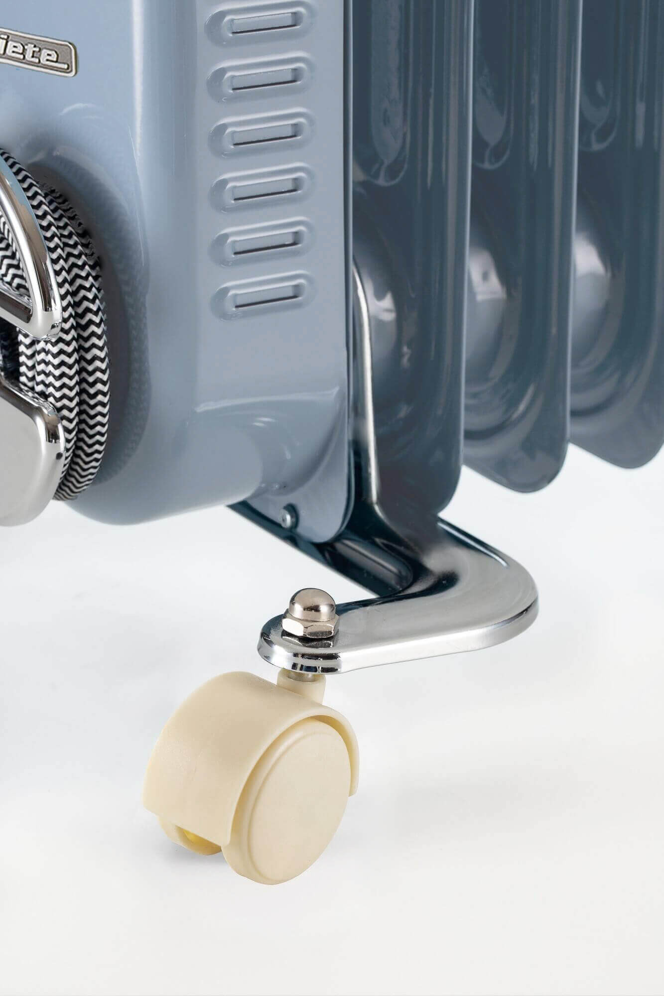 Close-up van een grijze en blauwe oliegevulde radiator met een crèmekleurig wiel.