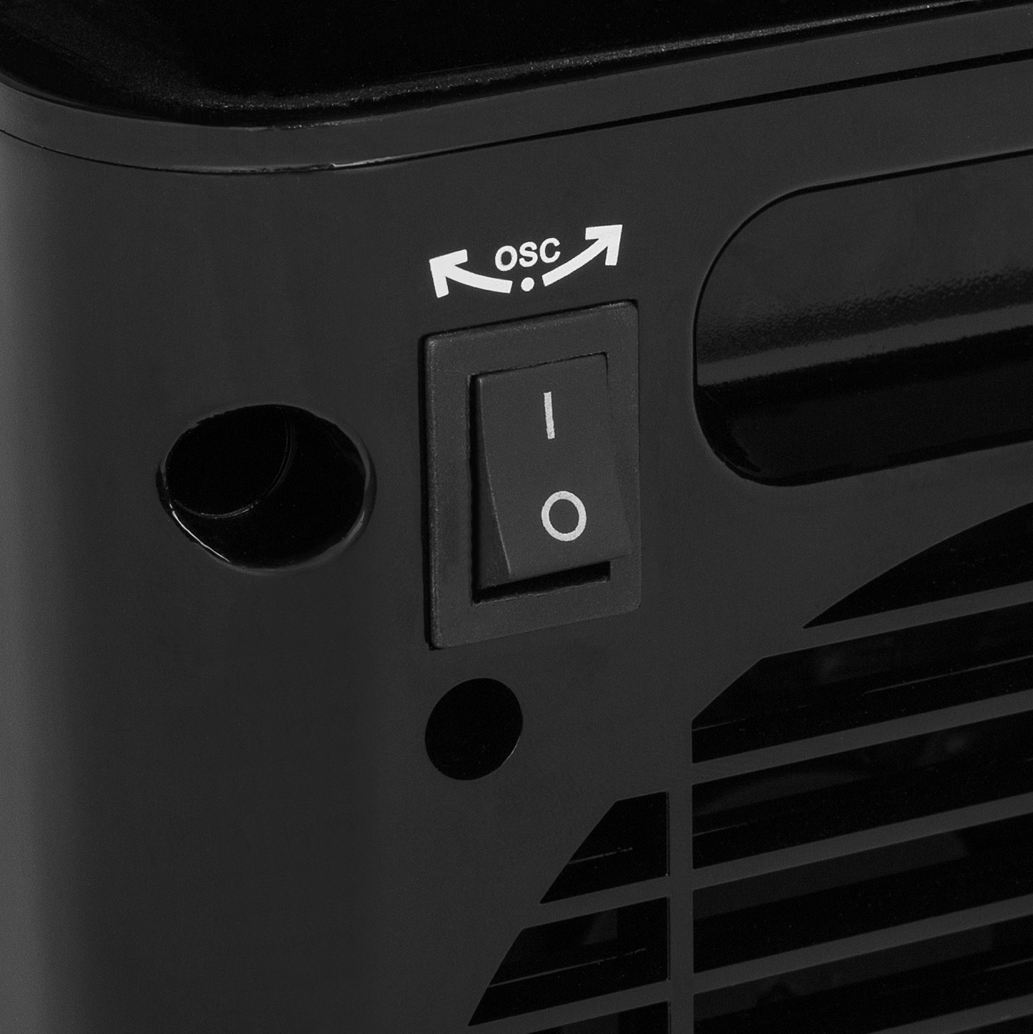 Primer plano de un electrodoméstico negro con un interruptor de encendido/apagado y un símbolo 'osc', probablemente un ventilador.