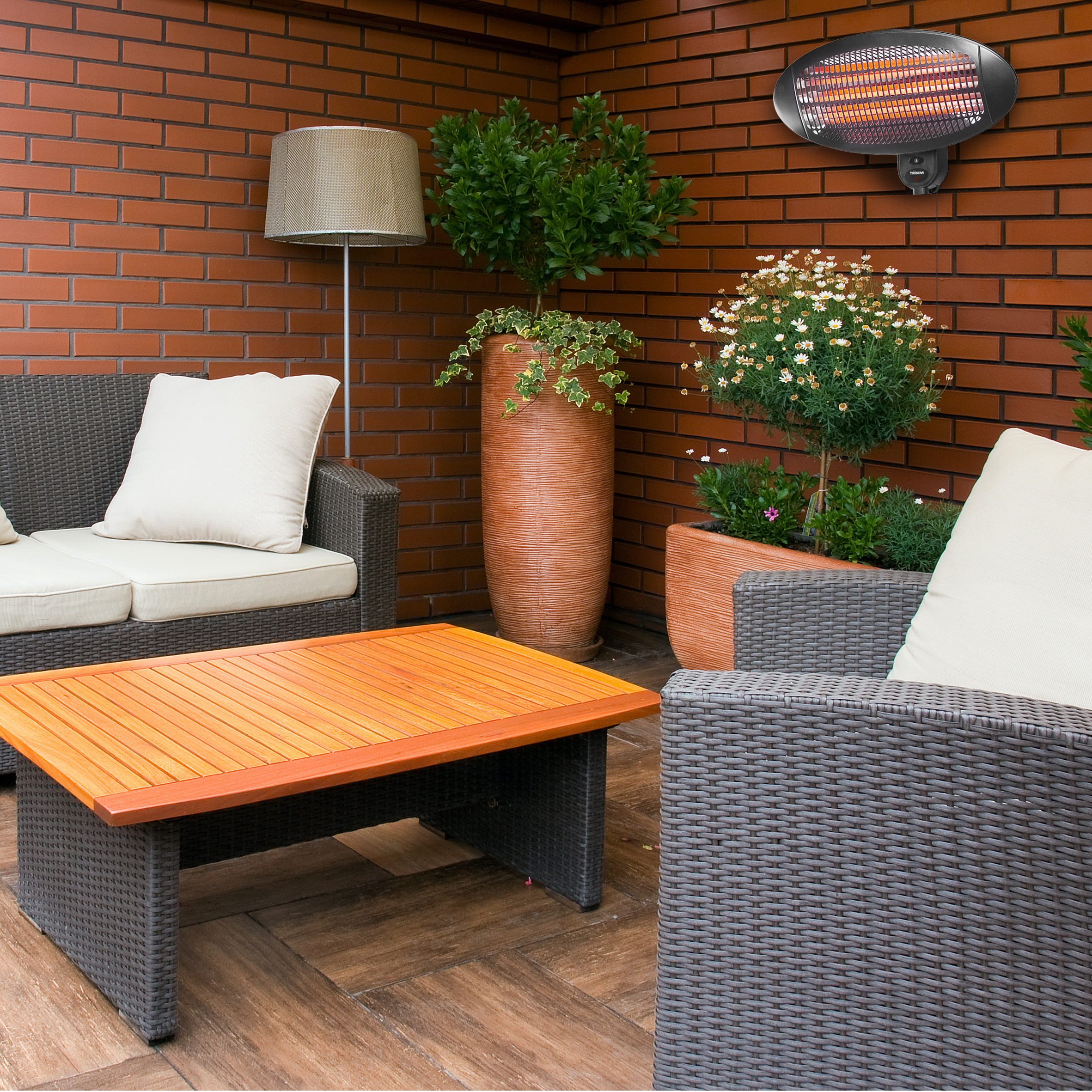 Außenbereich mit Backsteinmauer, Sofa und Heizung. Inklusive Pflanzen und Holztisch.