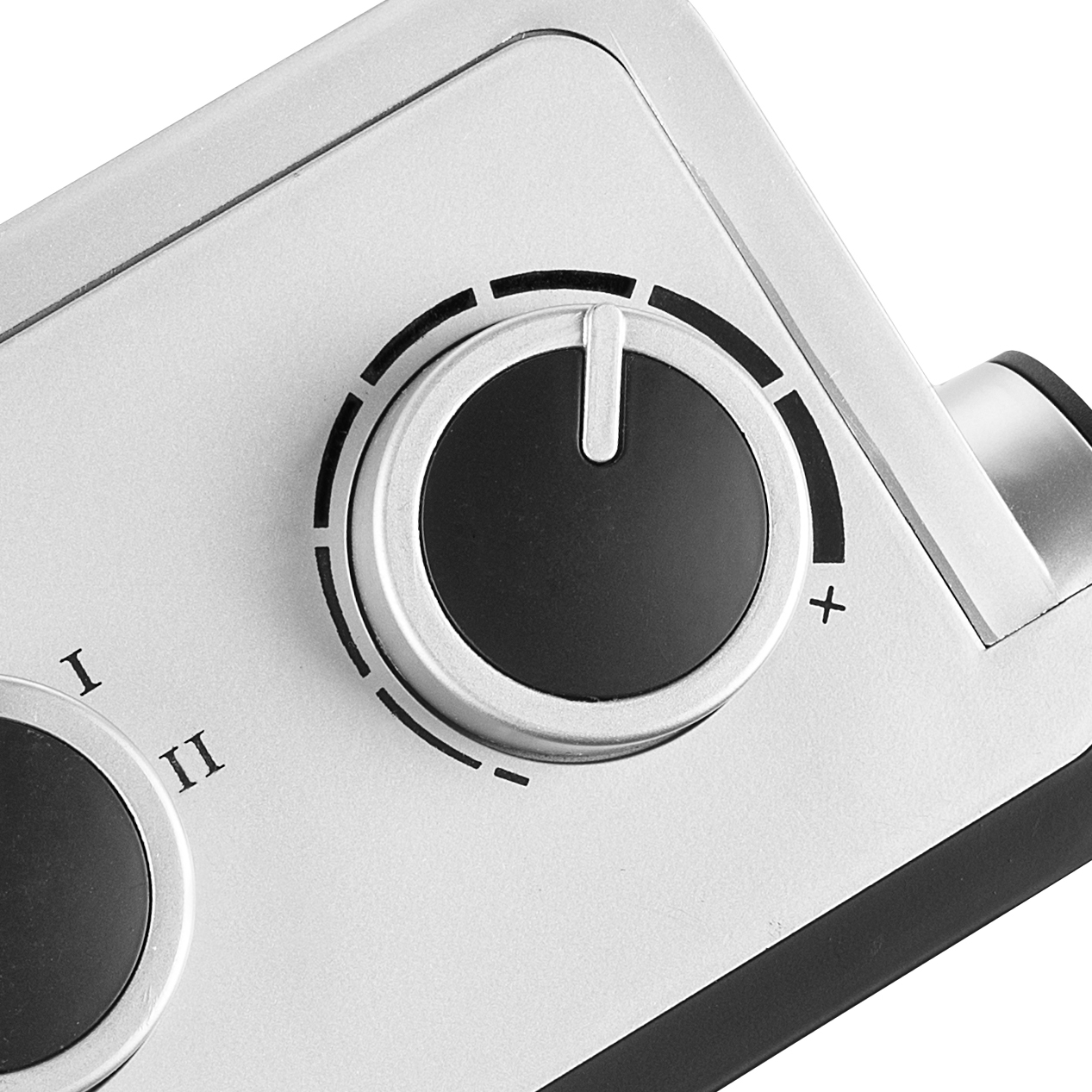 Zbliżenie srebrnego pokrętła z czarnym środkiem i białymi oznaczeniami, do regulacji ustawień.