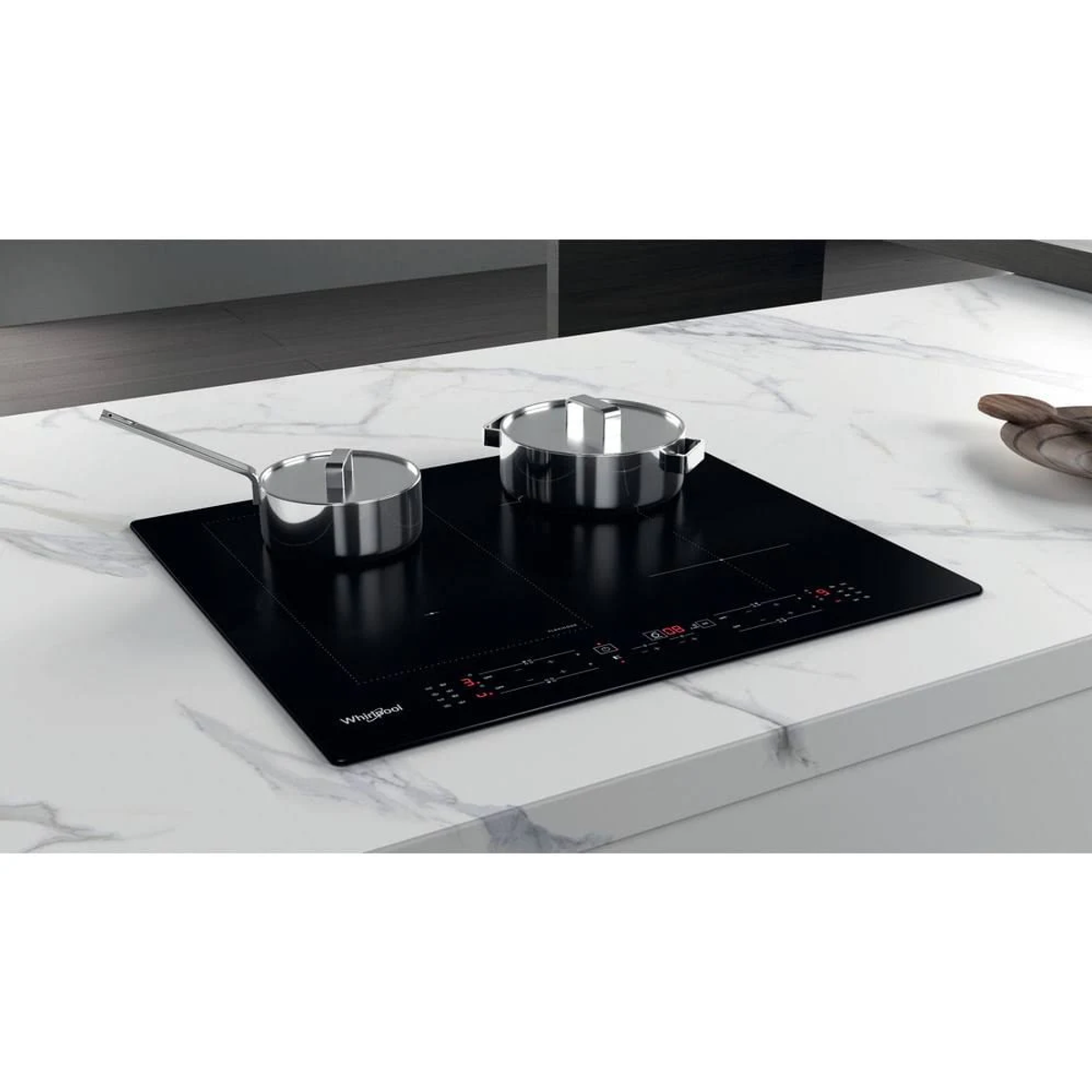 Dos ollas plateadas sobre una placa de inducción negra, colocadas sobre una superficie de mármol blanco.