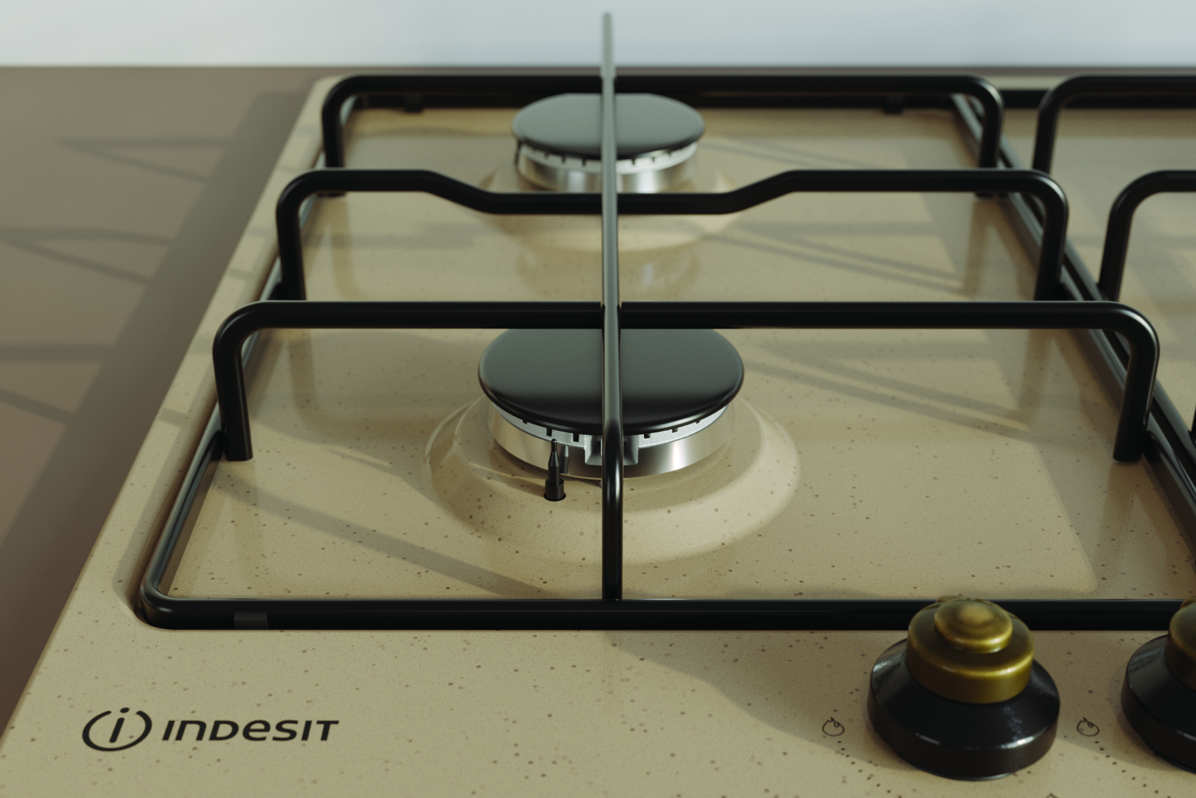 Zbliżenie beżowej płyty gazowej Indesit z czterema palnikami i czarnymi rusztami.