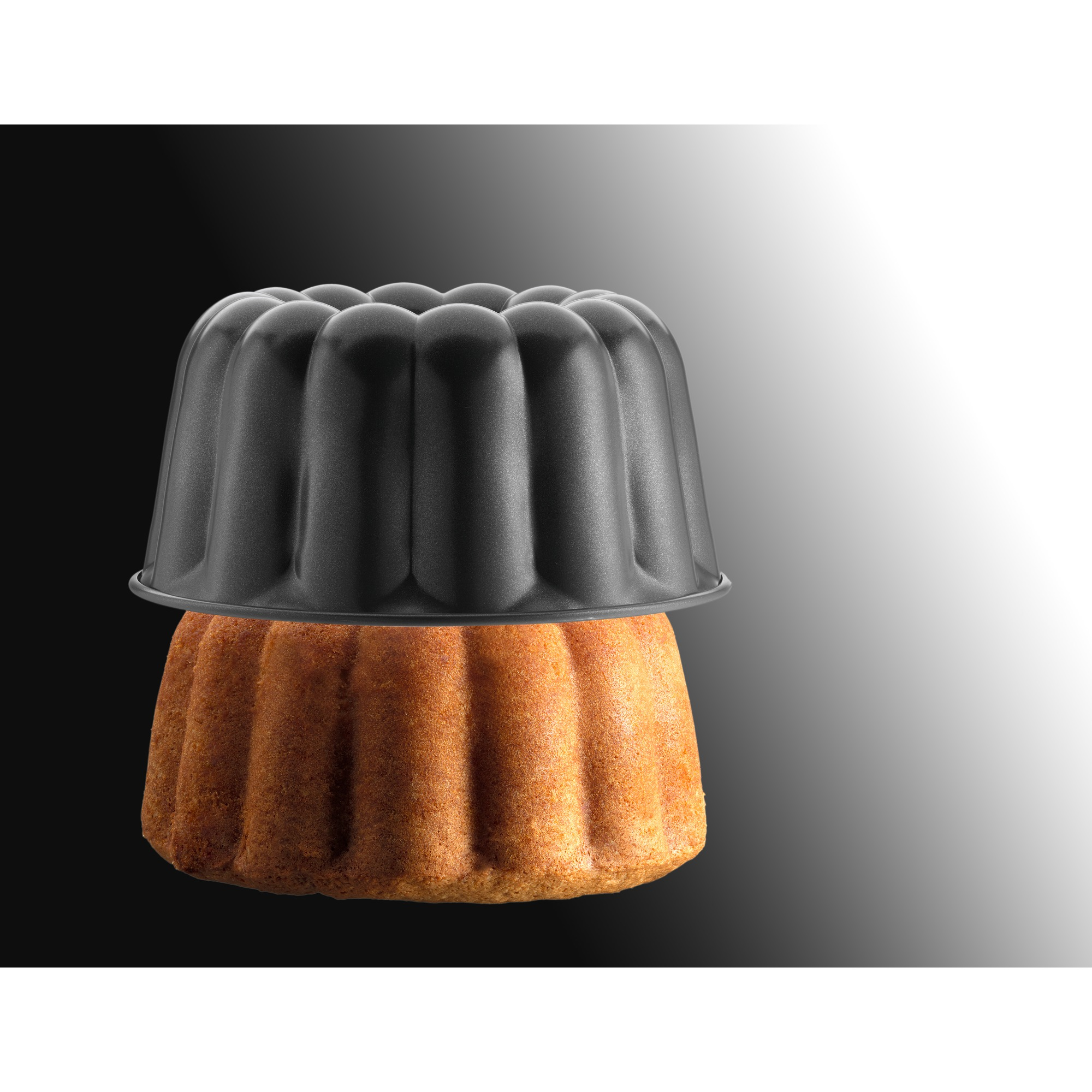 Babka z czarną formą do ciasta na wierzchu. Ciasto jest brązowe, a forma czarna.