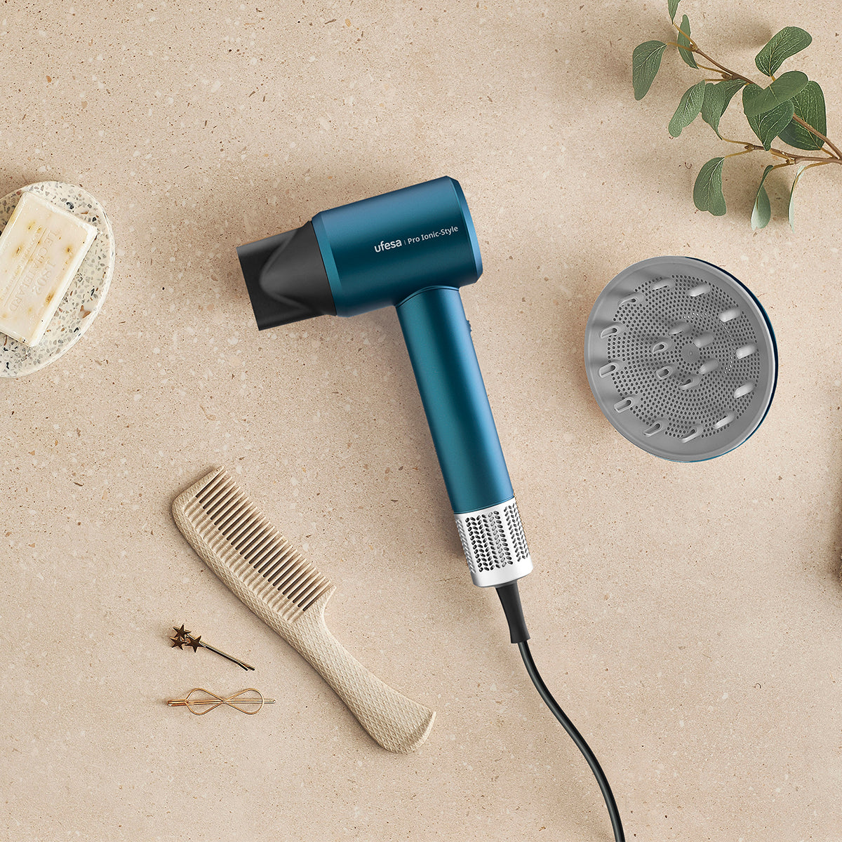 Secador de pelo, peine y accesorios en superficie beige, vista superior.