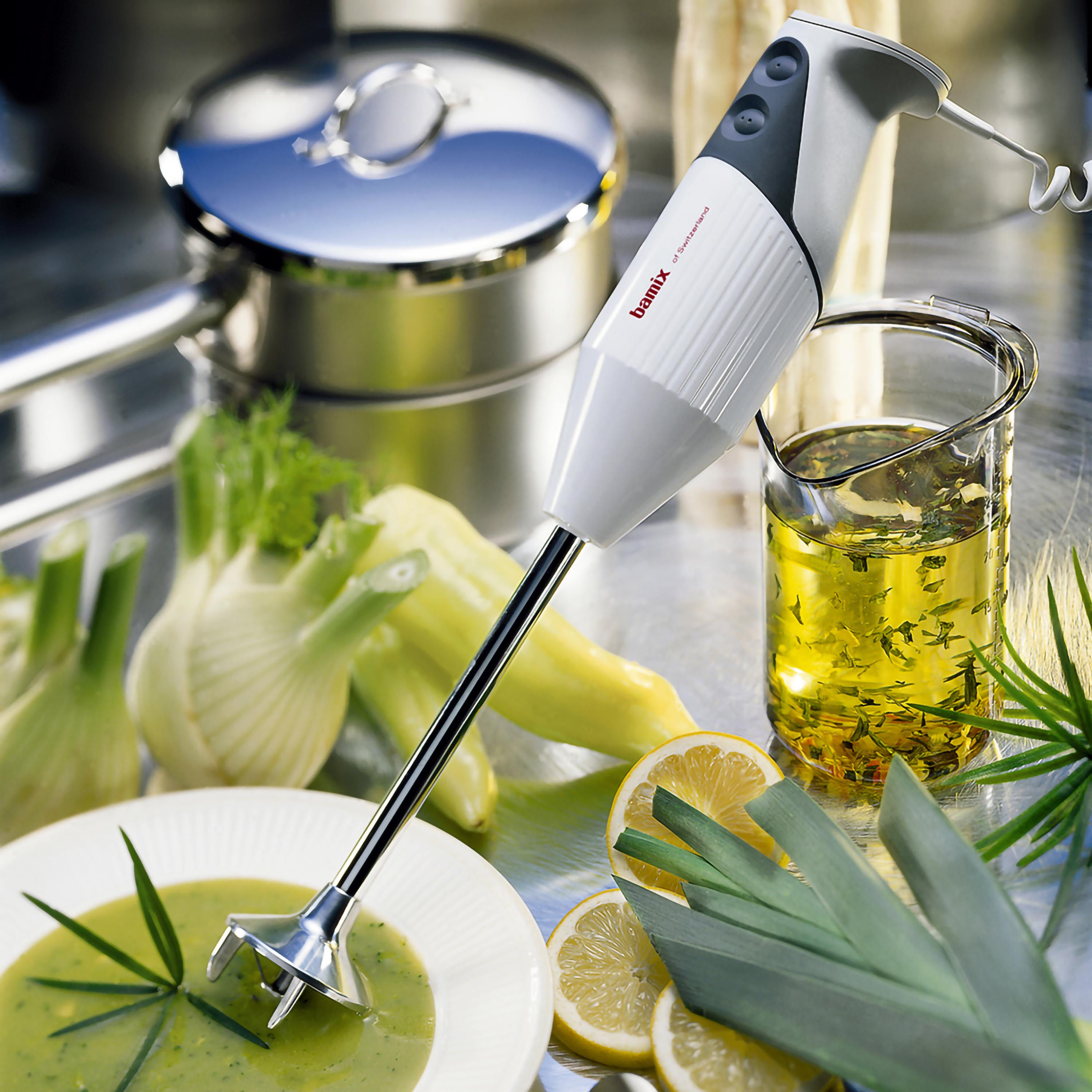 Frullatore a immersione in una scena con alimenti. C'è una zuppa verde.