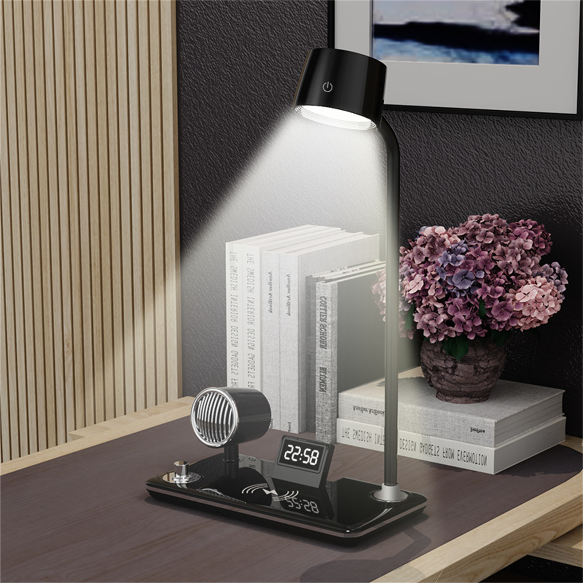 Eine Schreibtischlampe mit Lautsprecher, Digitaluhr und Blumenvase, die Licht auf Bücher wirft.