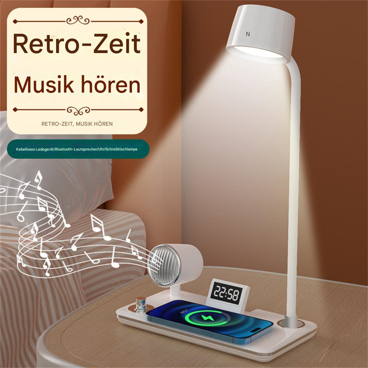 Eine weiße Schreibtischlampe mit Handy-Ladepad, Handy, Lautsprecher und Uhr auf einem Tisch.