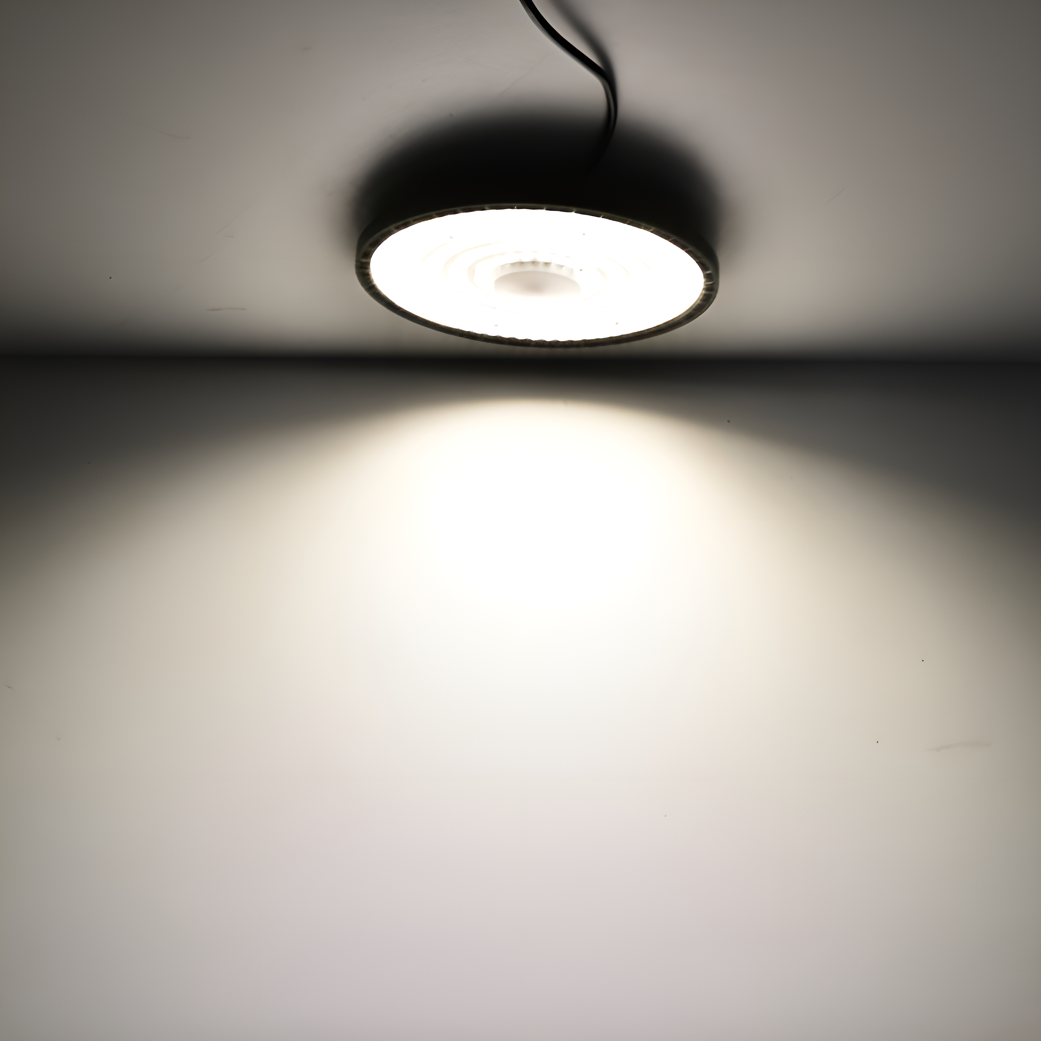 Runde weiße Deckenleuchte mit hellem Licht, das nach unten scheint.