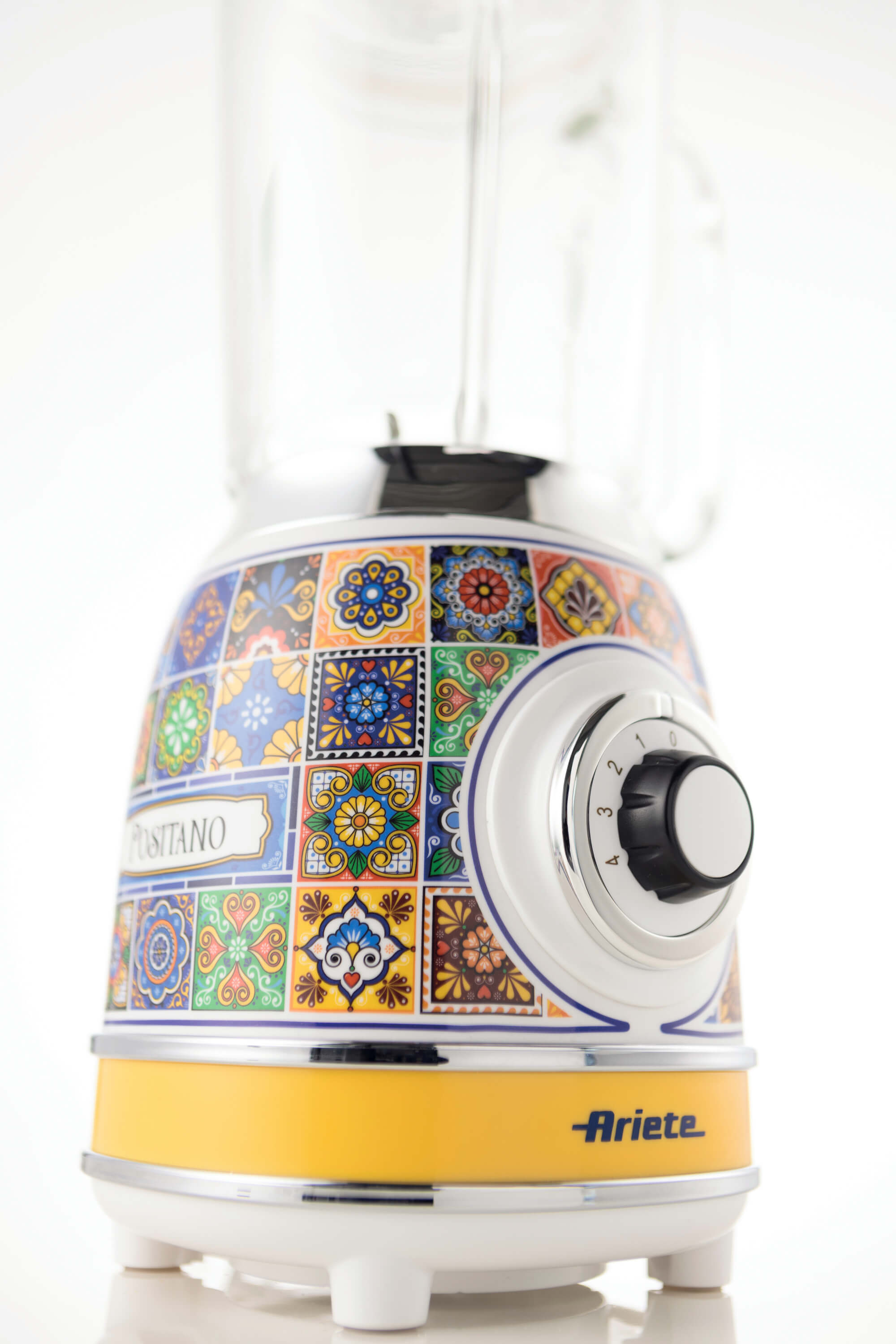 Beyaz tabanlı renkli Ariete blender. Cam kavanozu ve siyah kontrol düğmesi var.