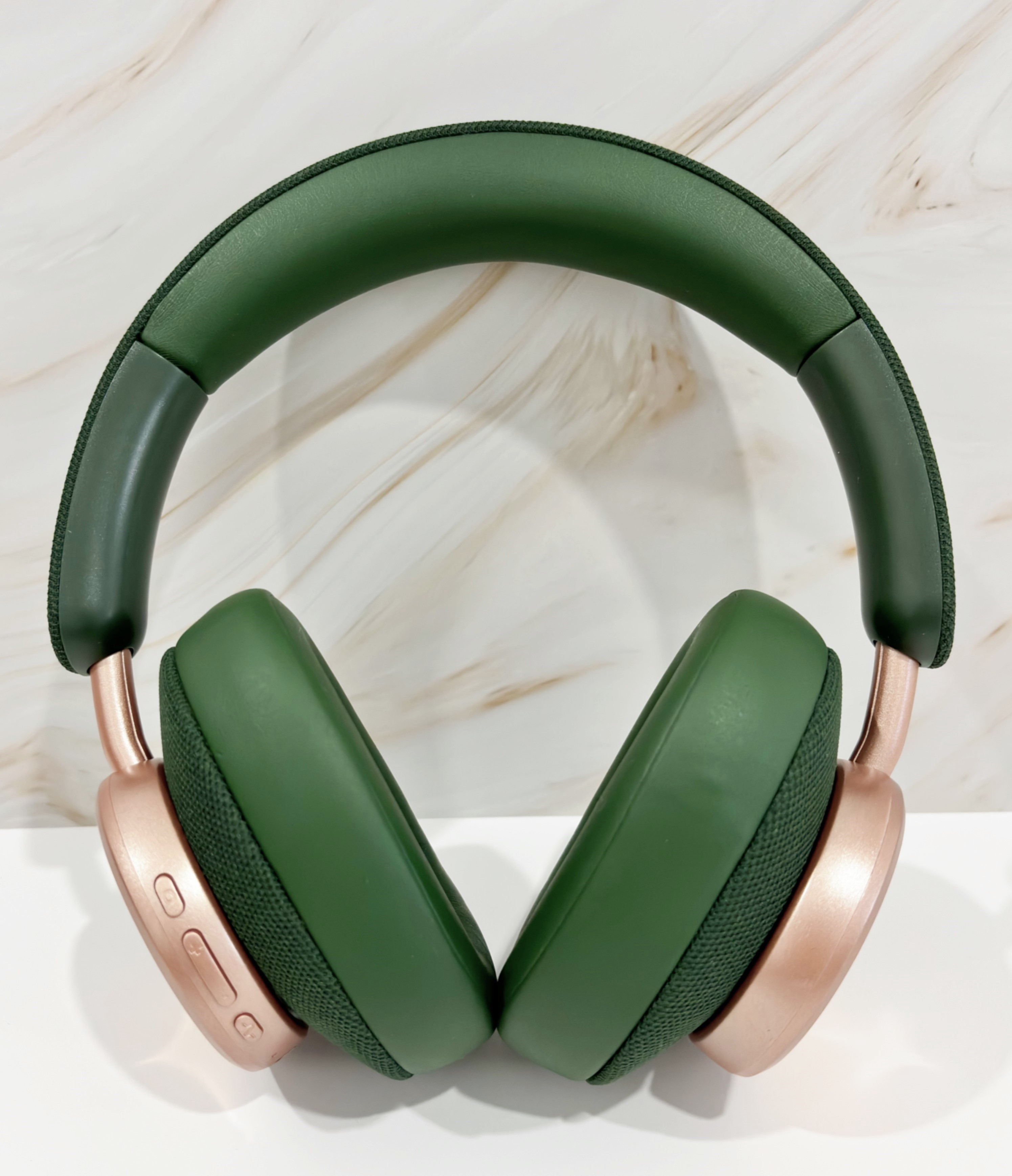 Auriculares verdes y dorados con orejeras y diadema visibles.