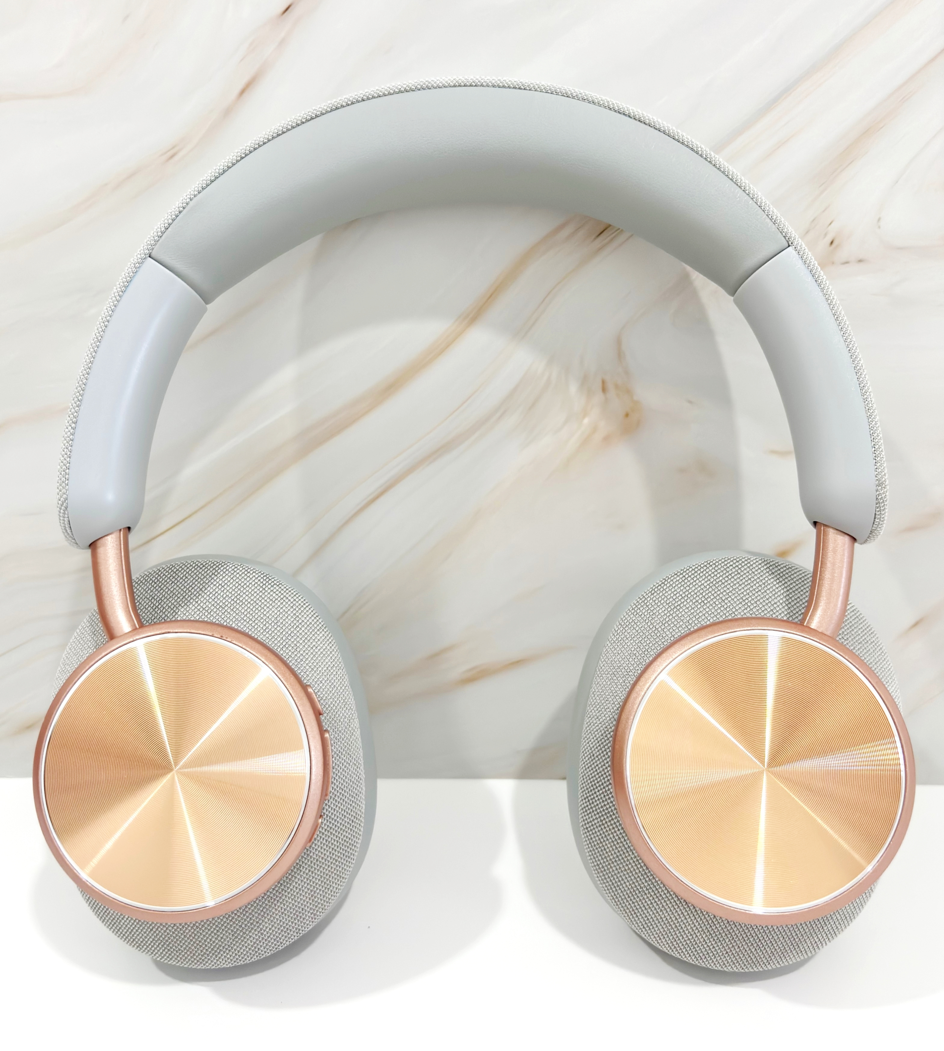 Auriculares con diadema gris, auriculares gris claro y detalles en oro rosa.