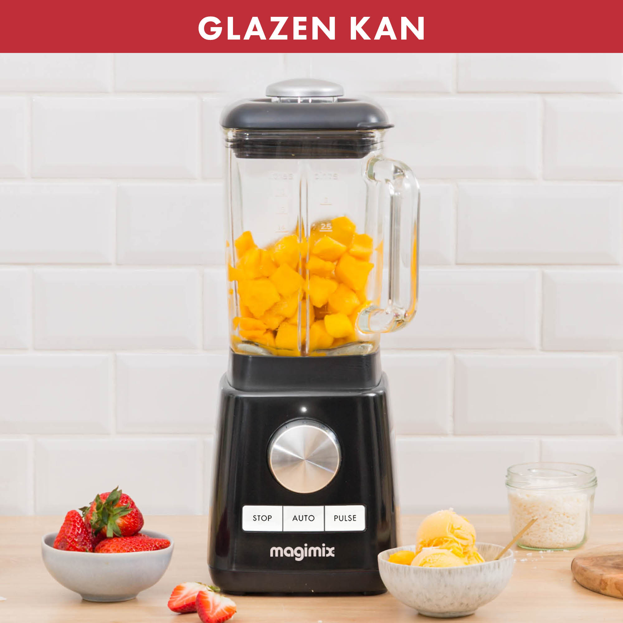 Zwarte blender met gele mango's in een glazen pot. Aardbeien en gele ijskommen aan de zijkant.