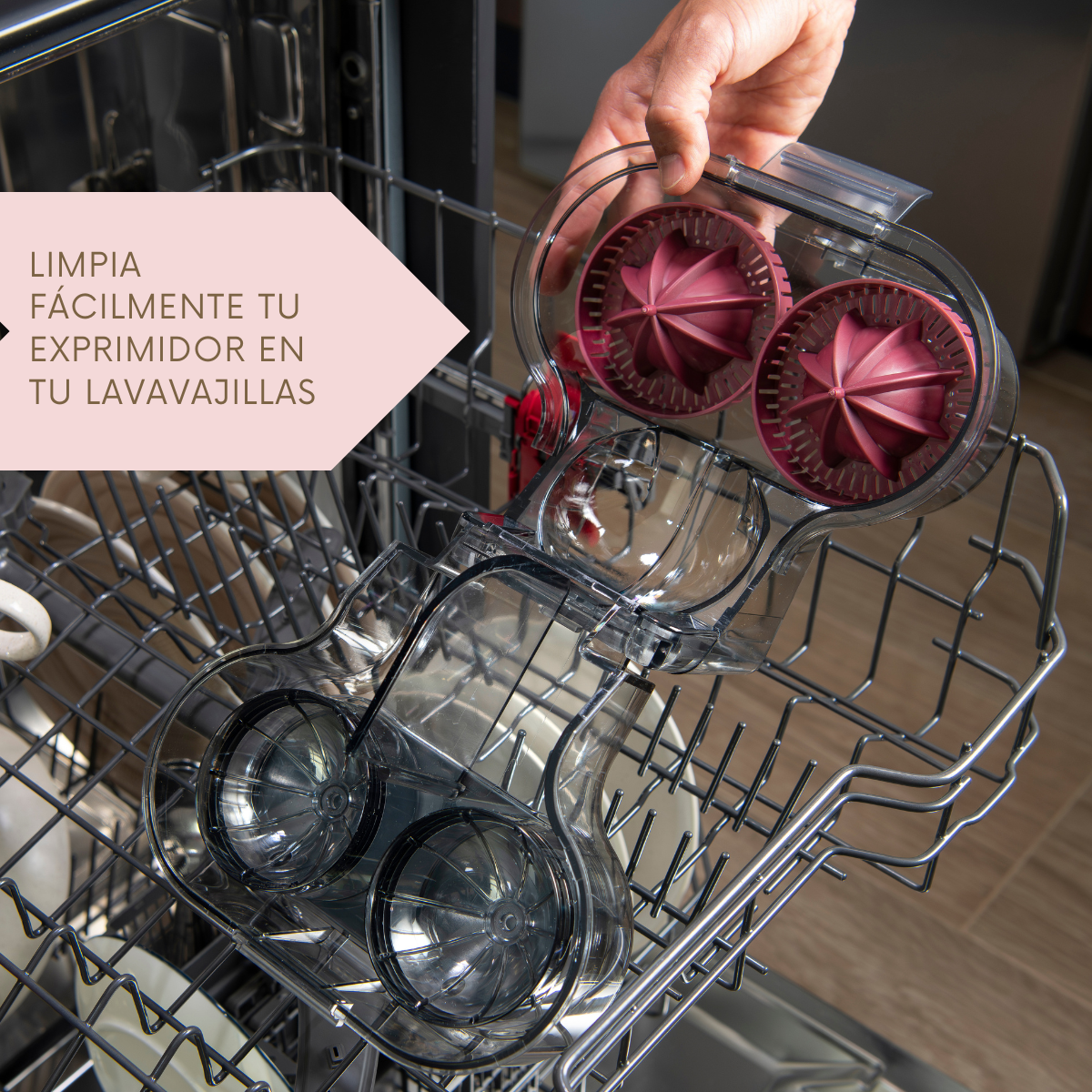 Una mano coloca partes de una exprimidora en un lavavajillas. Texto: 'LIMPIA FÁCILMENTE TU EXPRIMIDOR...'