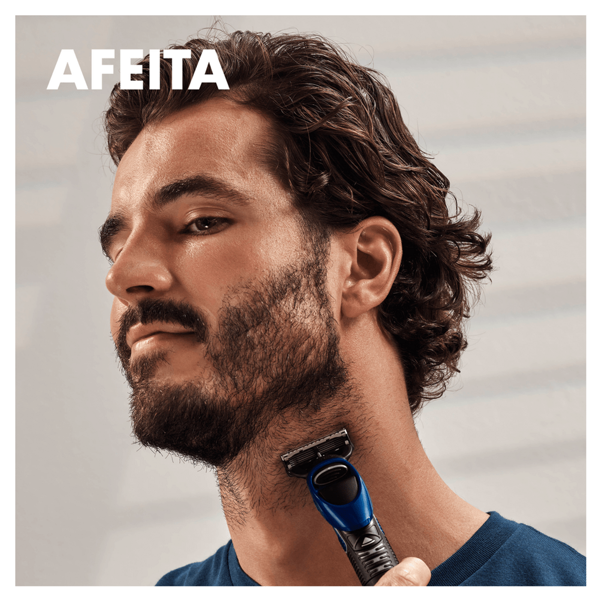 Un hombre afeitándose el cuello con una afeitadora azul y negra.