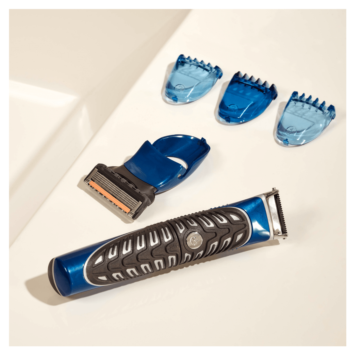 Recortadora azul con protectores. Incluye soporte y tres protectores azules. Fondo blanco.