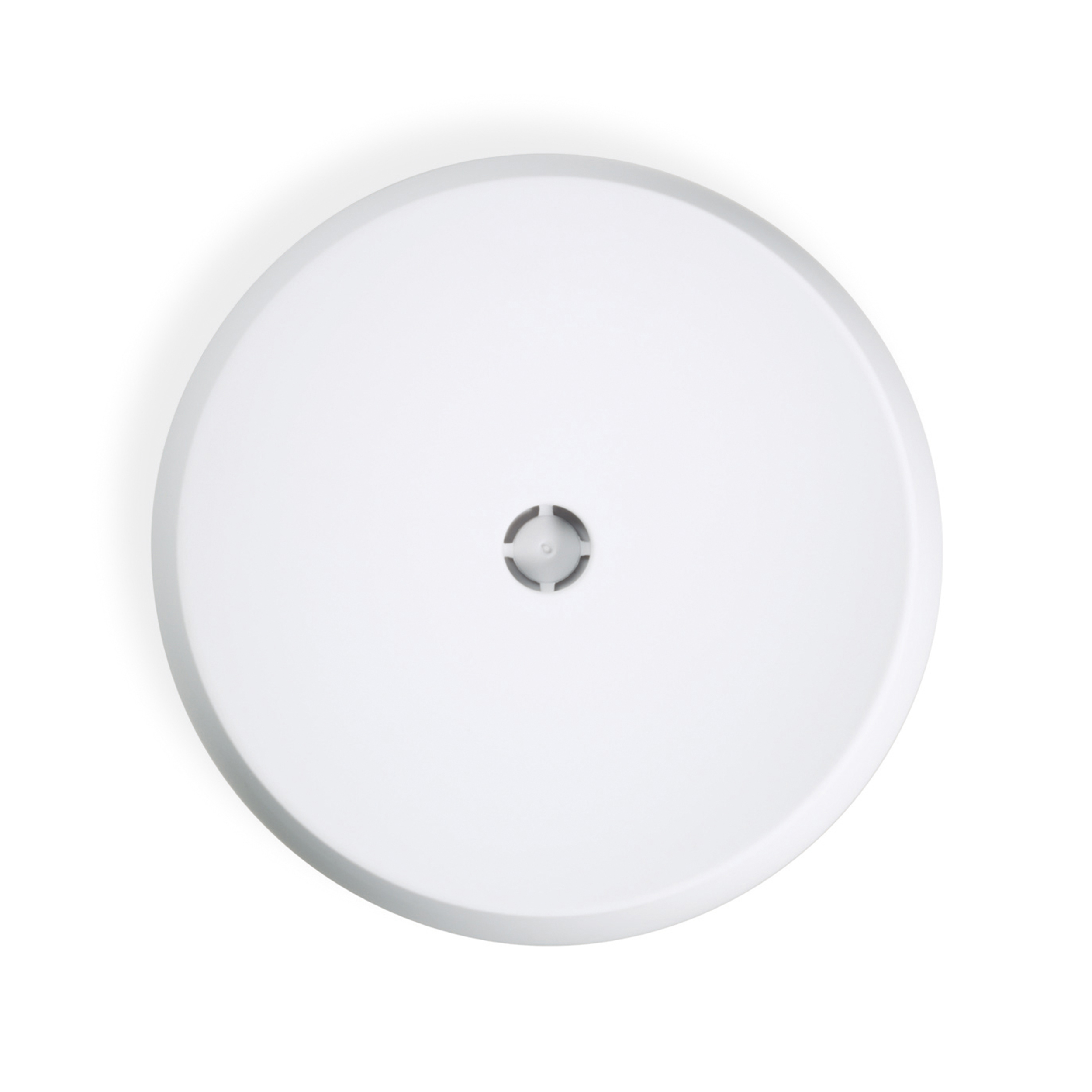 White, round, flat object. A small, dark, circular design is in the center.