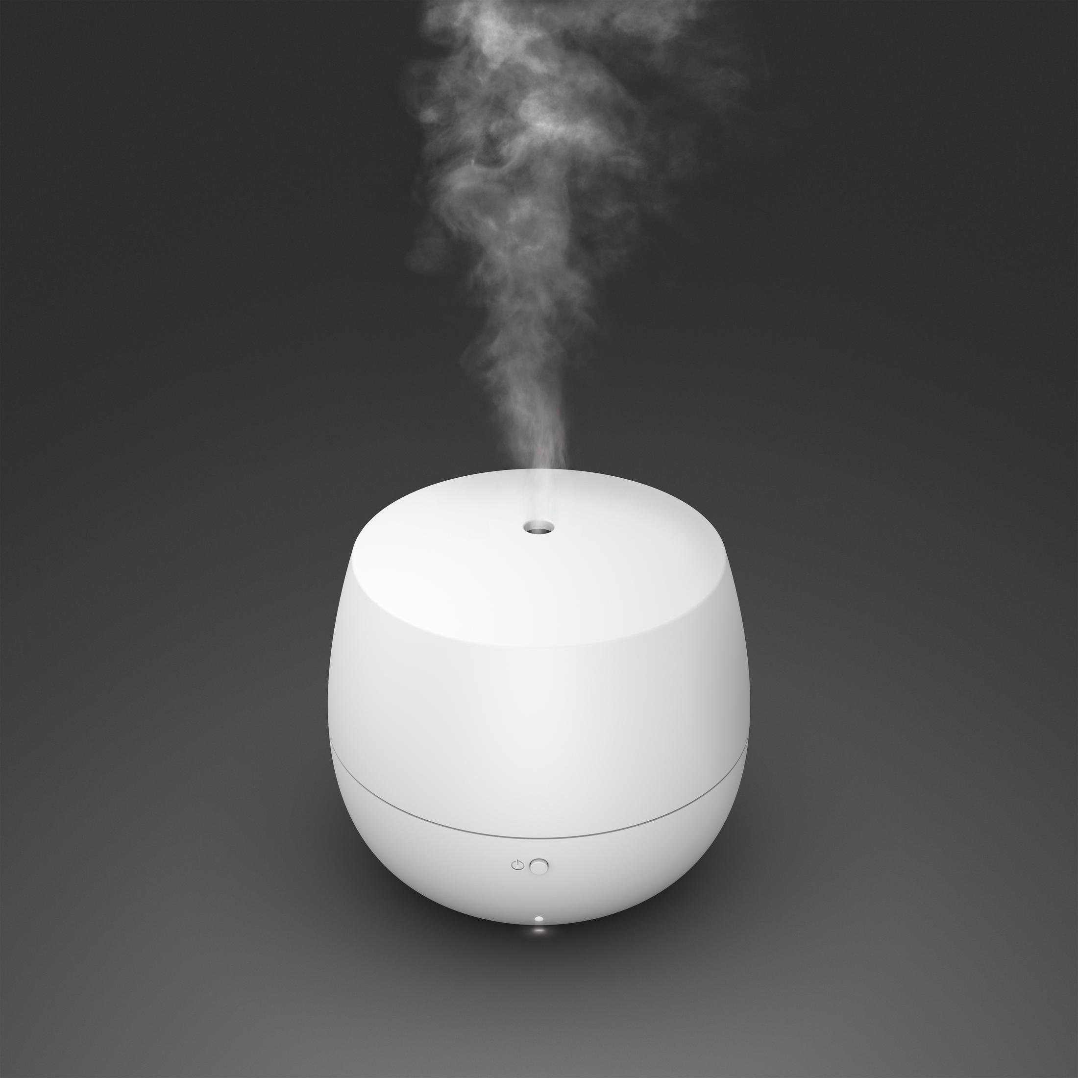 White oval humidifier with steam rising against a dark gray background.
