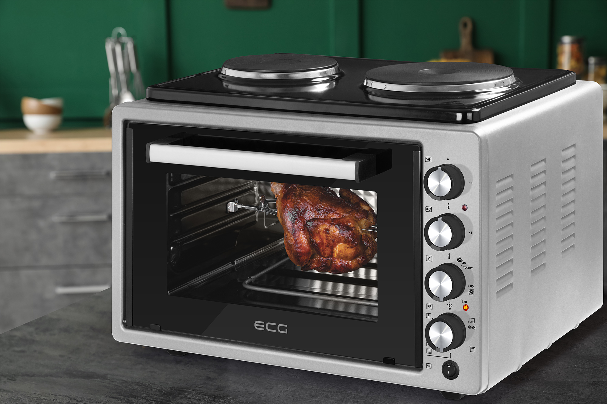 Kleiner silberner Ofen mit einem gekochten Huhn im Inneren, mit zwei Kochplatten oben.