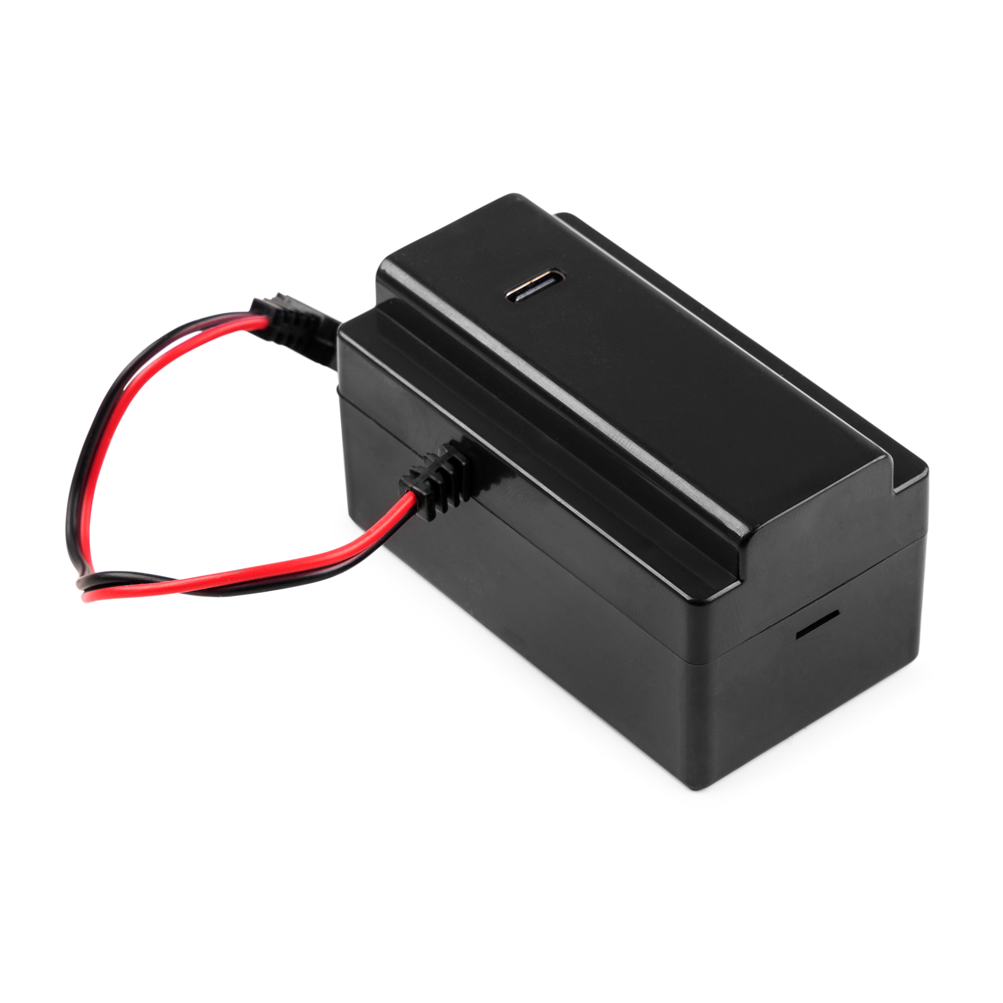 Dispositivo de carga rectangular negro con cables rojos y negros adjuntos.