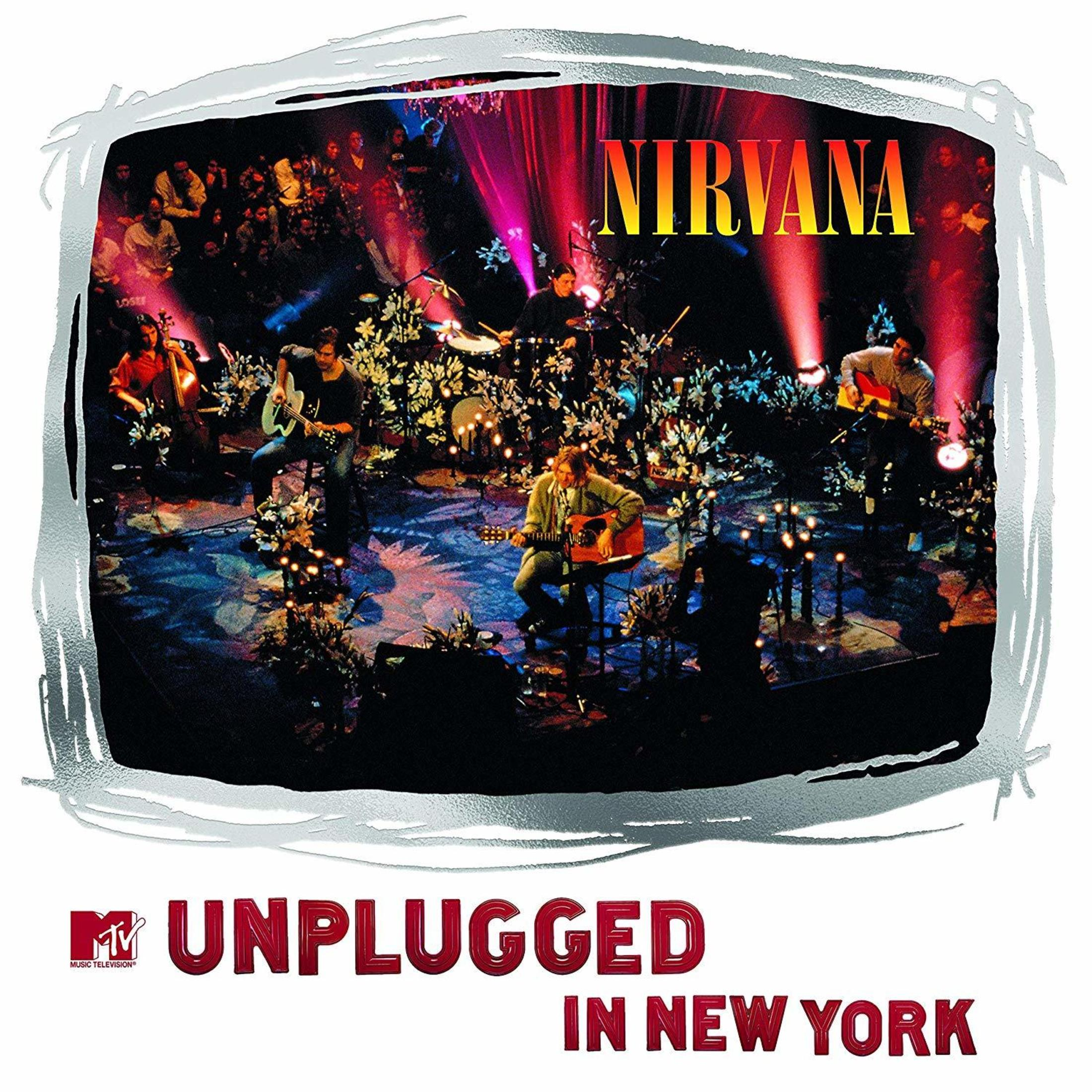 Foto di un concerto dal vivo: Banda sul palco, pubblico visibile, luci di scena e testo Nirvana.