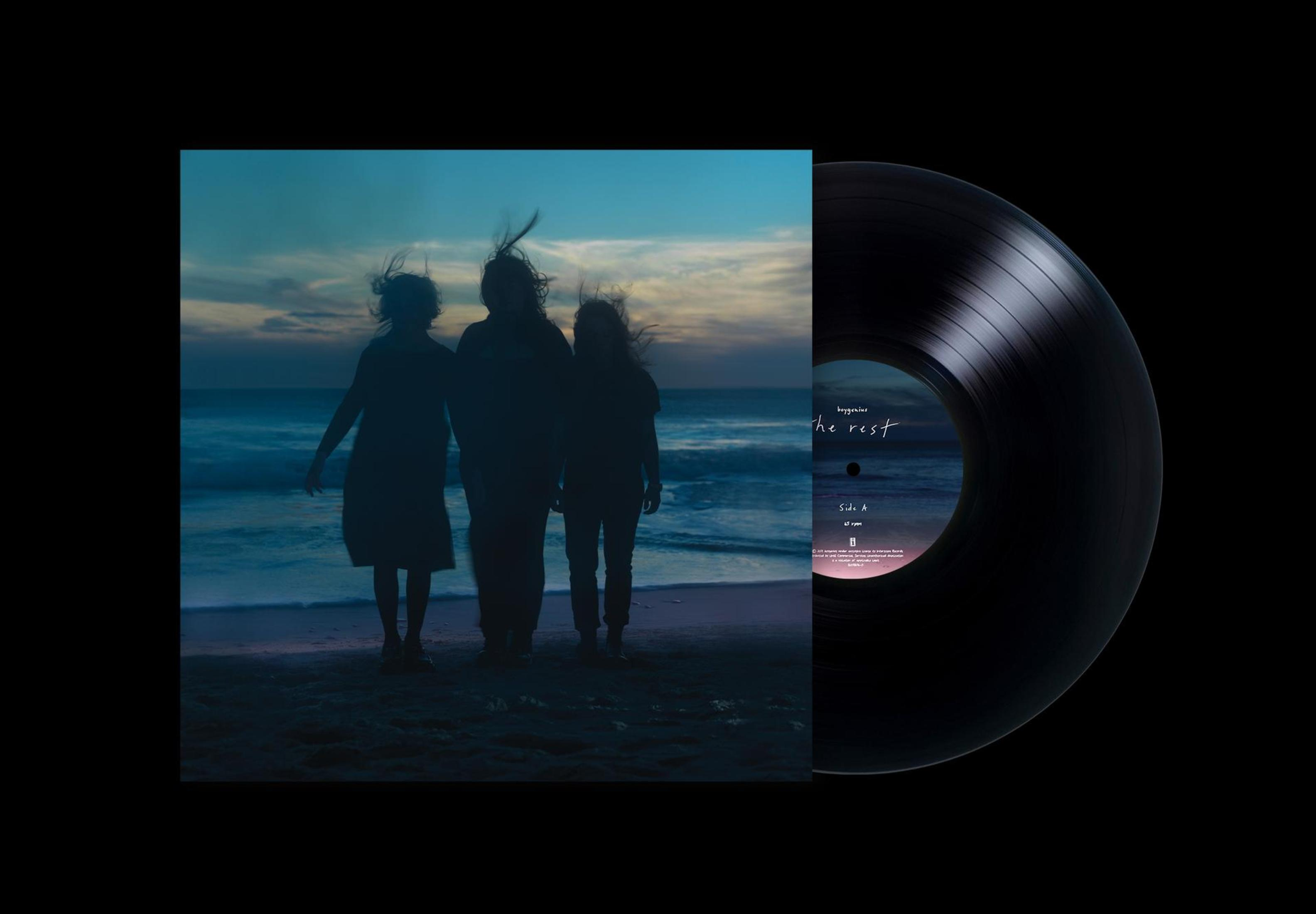 Album cover: Three figures on a beach, facing the sea at sunset, and a black vinyl record.