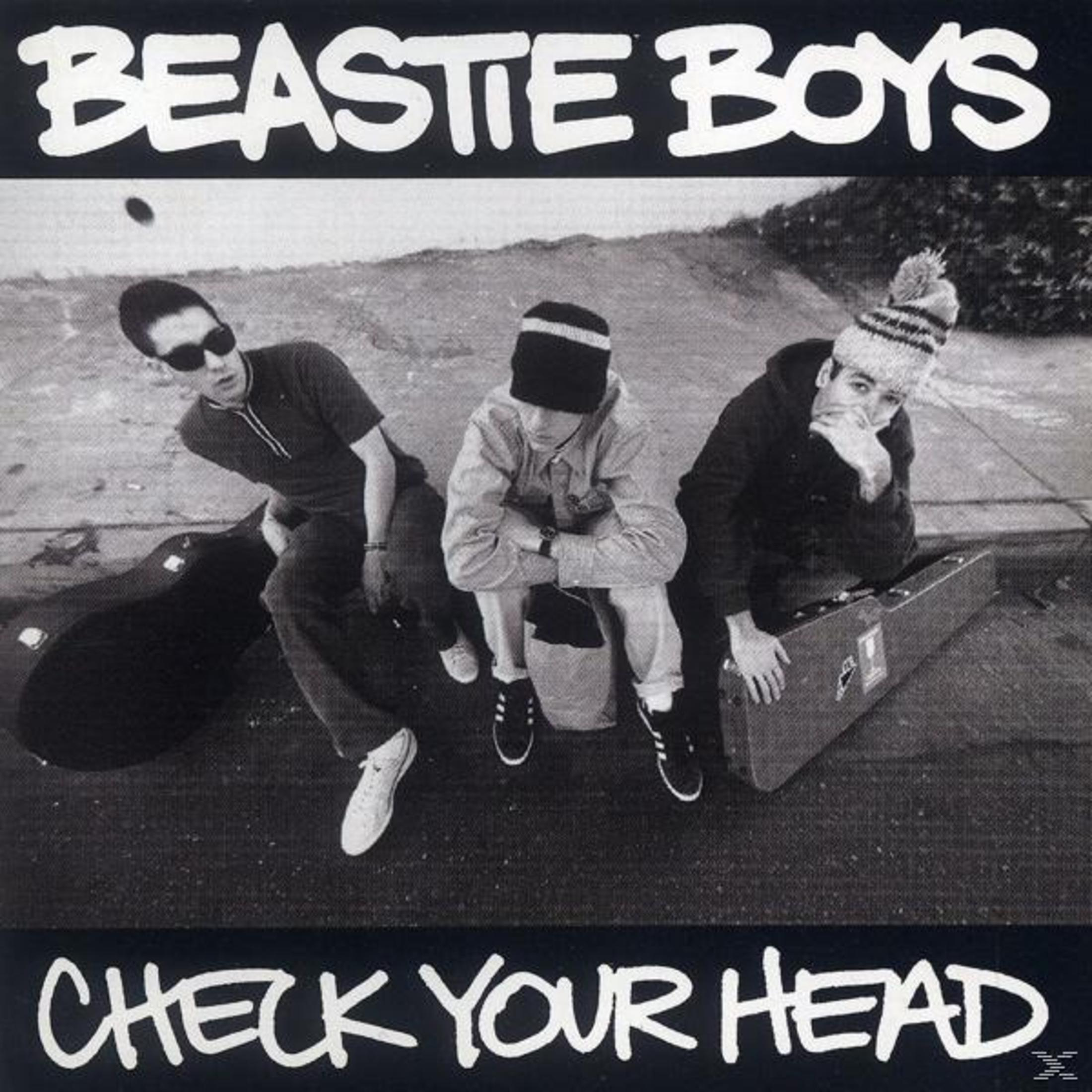 Copertina dell'album dei Beastie Boys. Tre uomini per strada, due con occhiali da sole. Titolo in alto: Check Your Head.