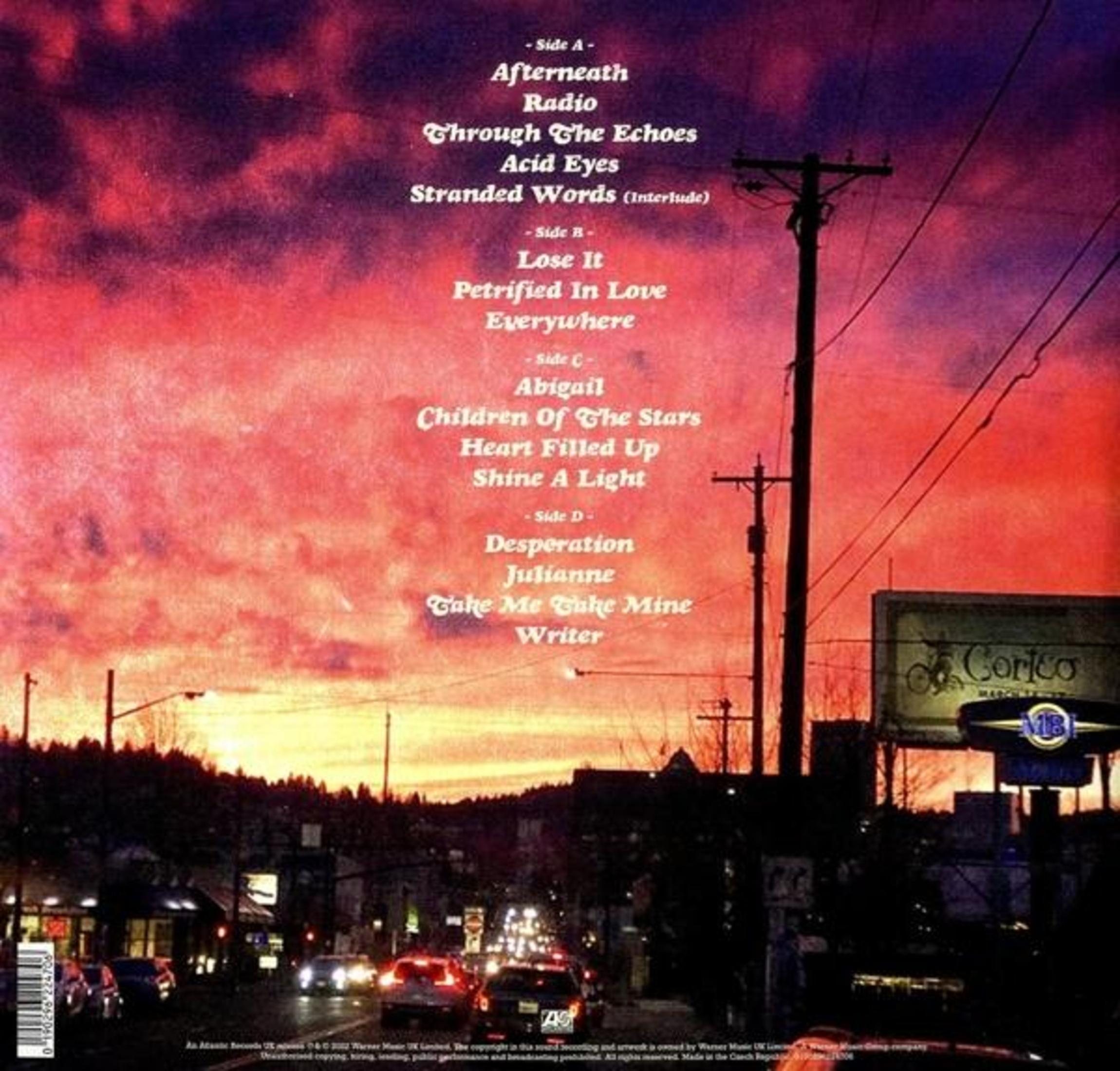 Retro copertina album con paesaggio urbano al tramonto e tracklist con testo bianco.
