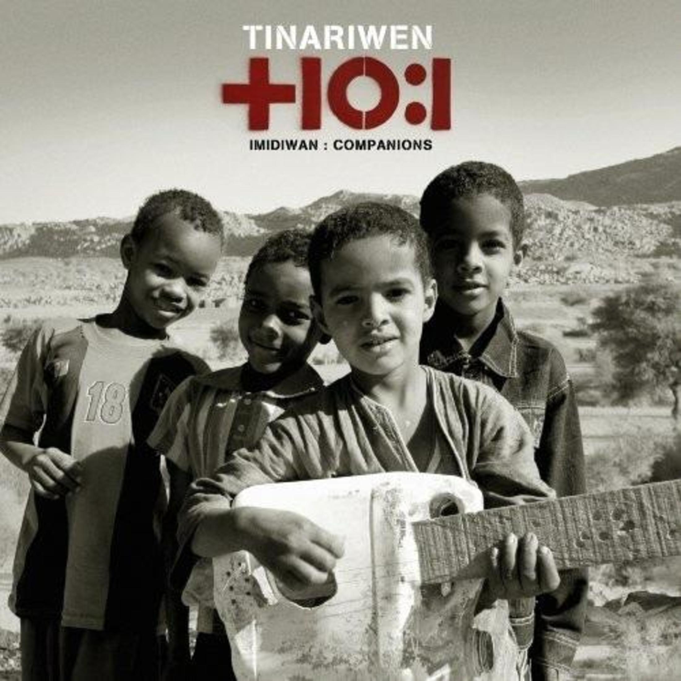 Quattro bambini, uno con una chitarra, insieme. La copertina dice 'Tinariwen'.