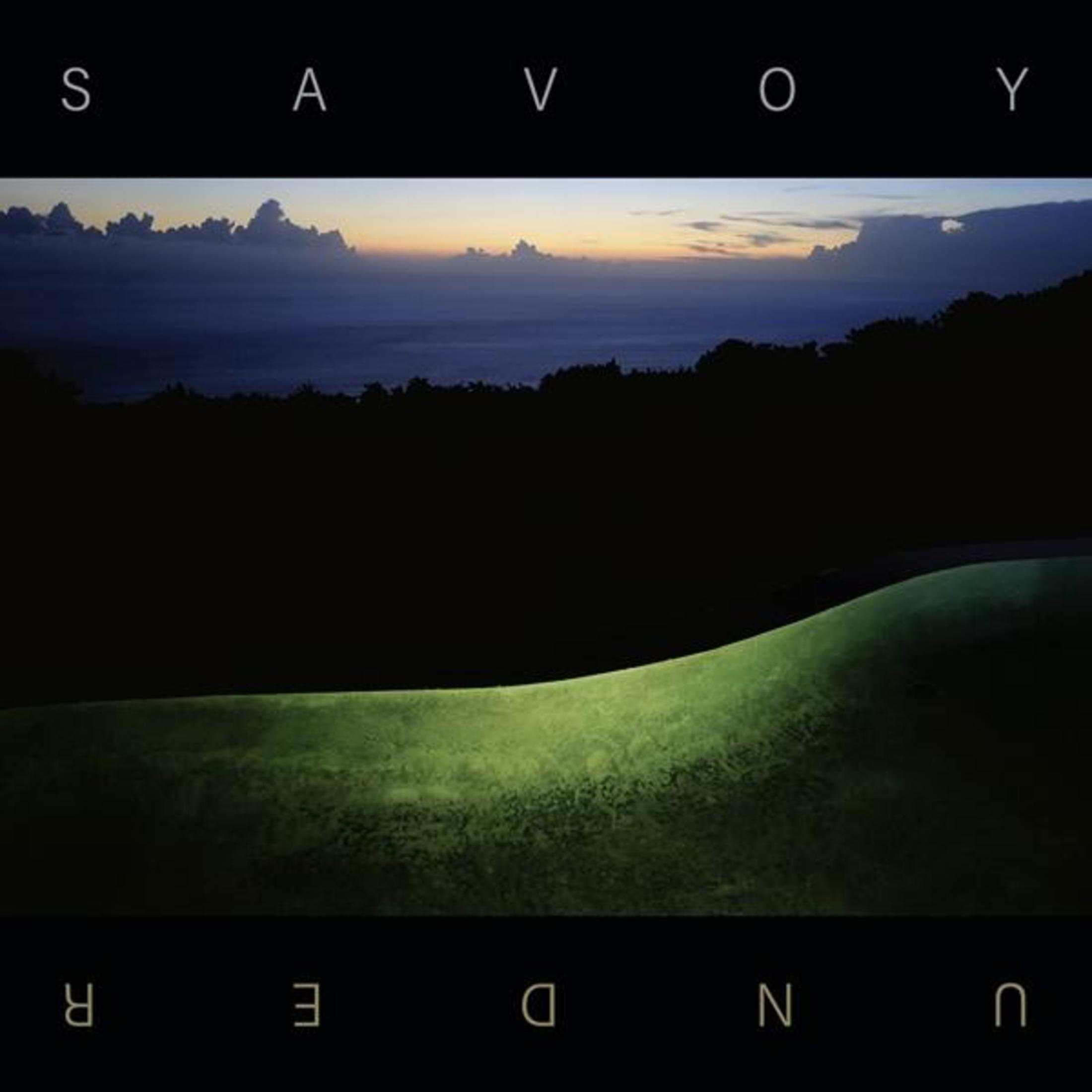 Copertina: Paesaggio scuro. Campo verde con una piccola luce. Titolo Savoy Under. Barre nere sopra e sotto.
