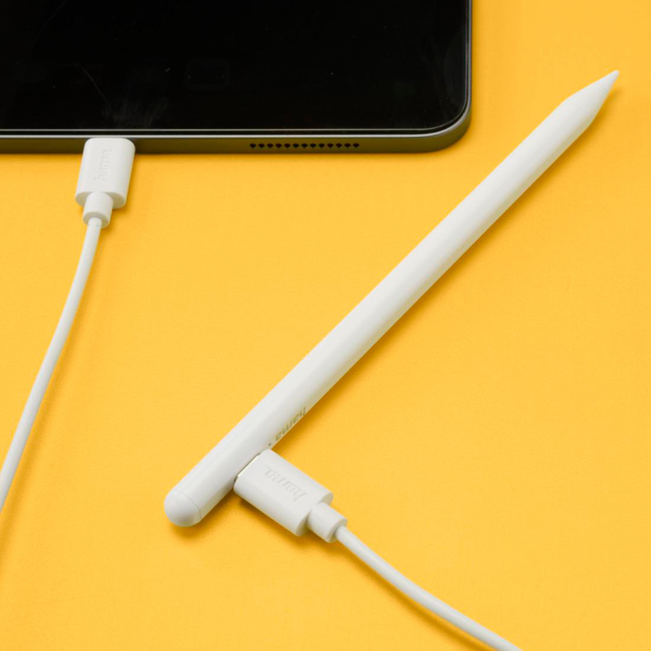 Una penna bianca che carica un iPad con un cavo bianco su sfondo giallo.