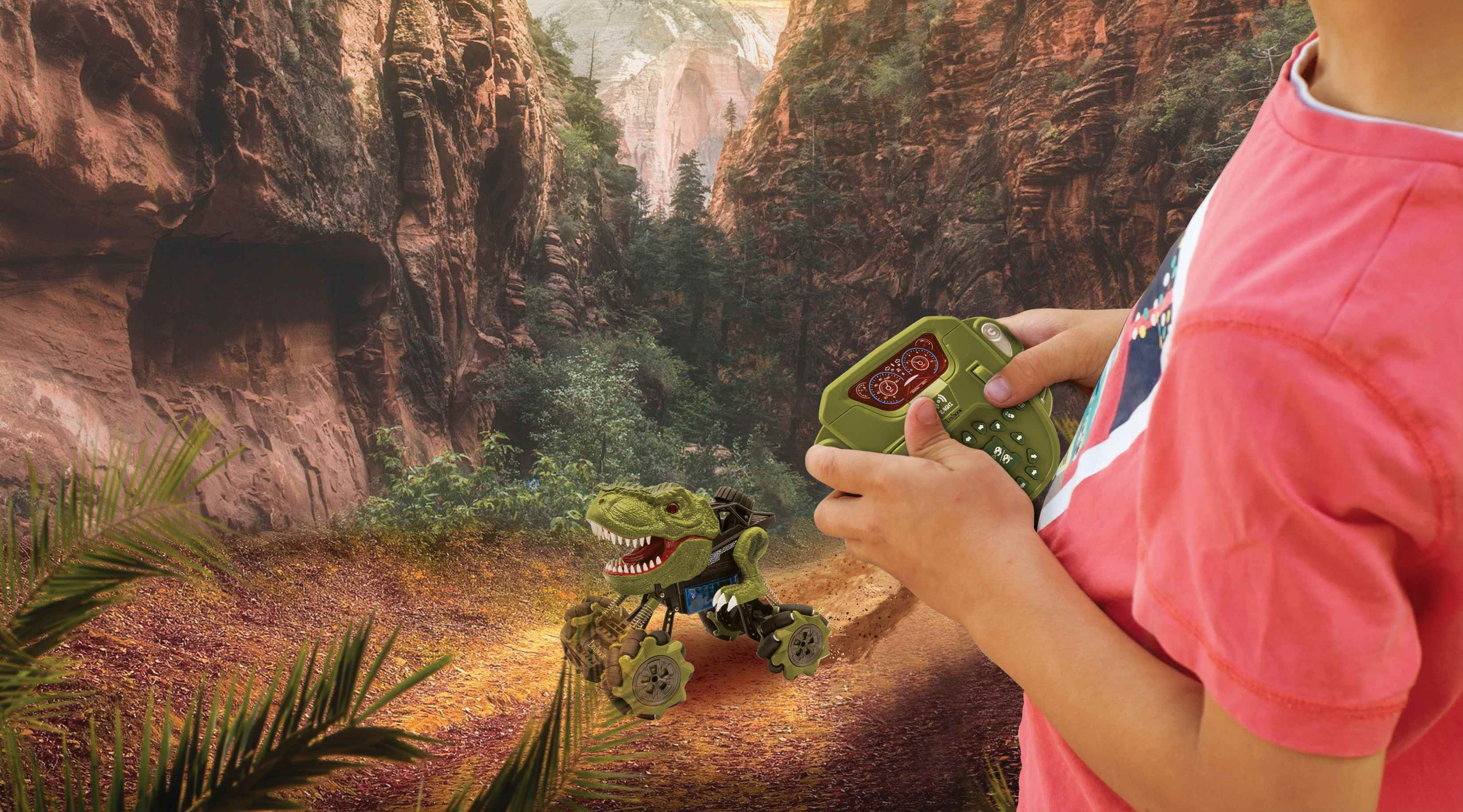 Un niño controla un juguete de dinosaurio con un control remoto en un entorno de cañón.