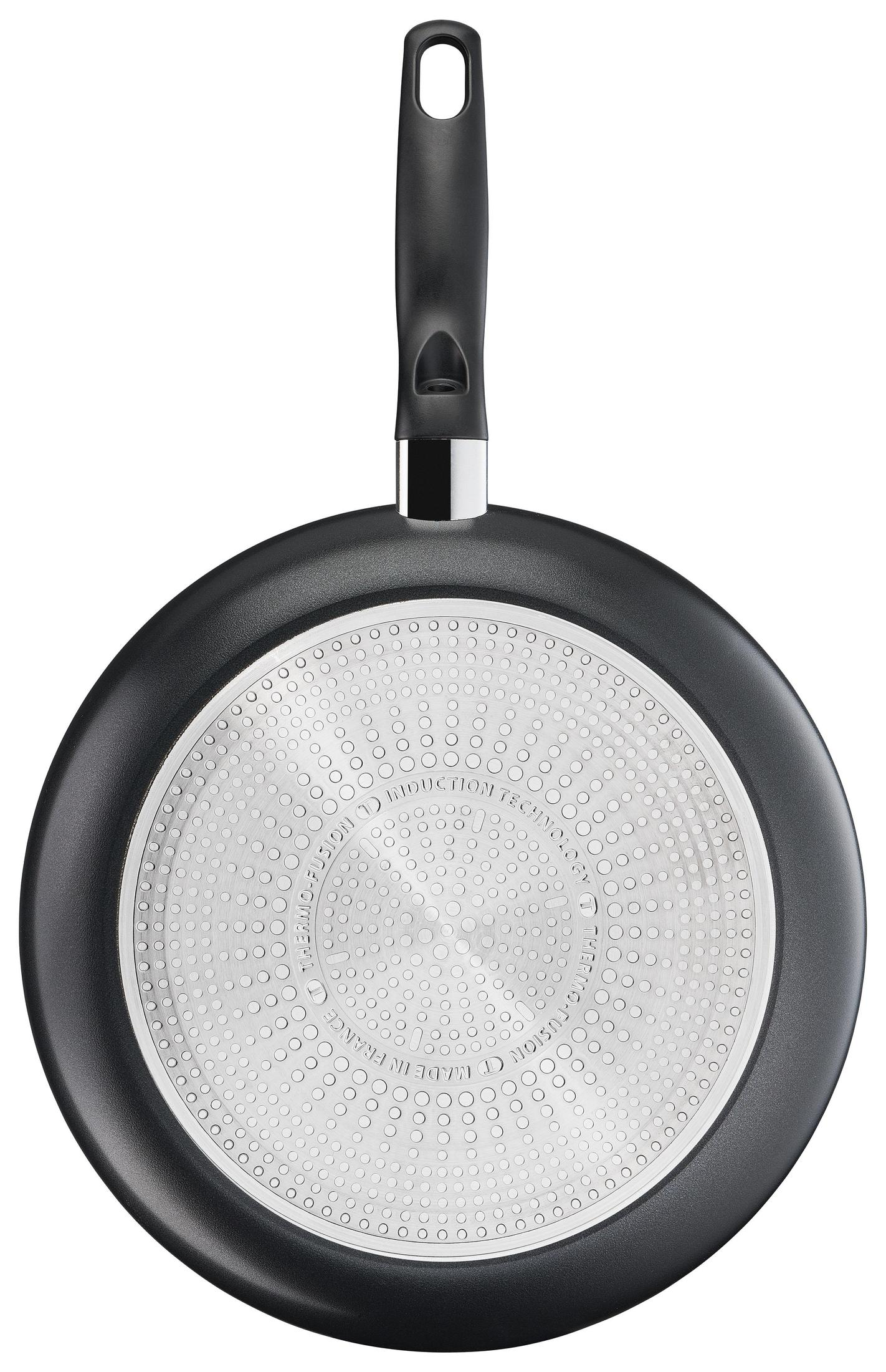 A black frying pan with a handle. The bottom has a silver, textured surface with dots.