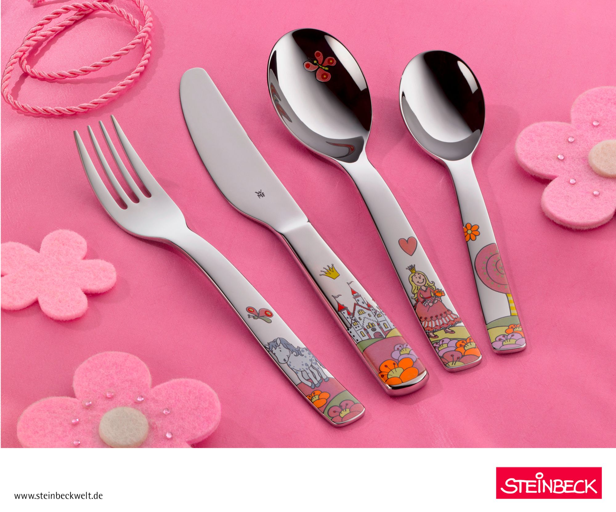 Cztery sztuki sztućców dla dzieci na różowej powierzchni, widelec, nóż i dwie łyżki z kolorowymi wzorami.