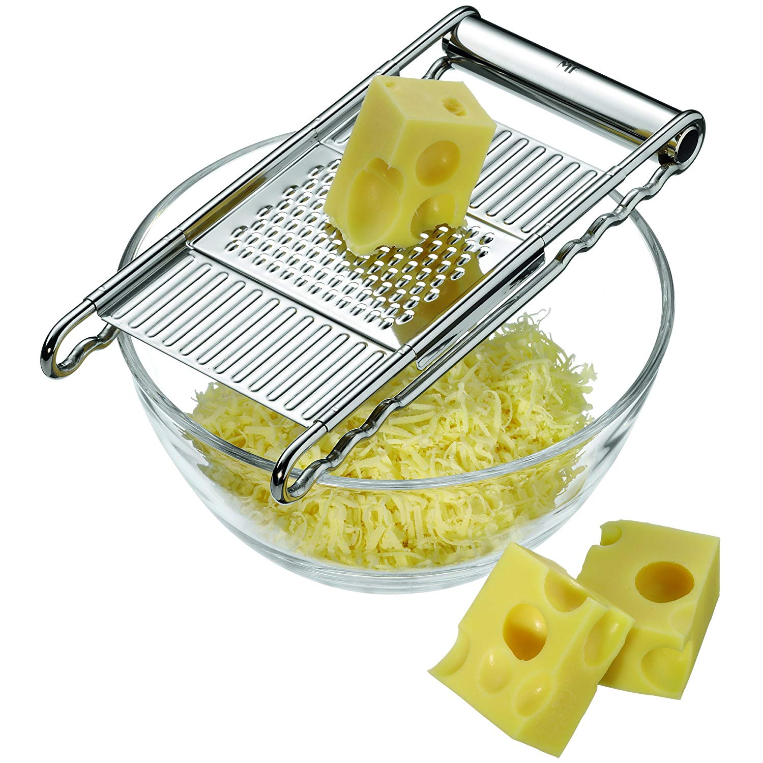 Grattugia per formaggio sopra una ciotola di vetro piena di formaggio grattugiato, con due cubetti di formaggio sul lato.