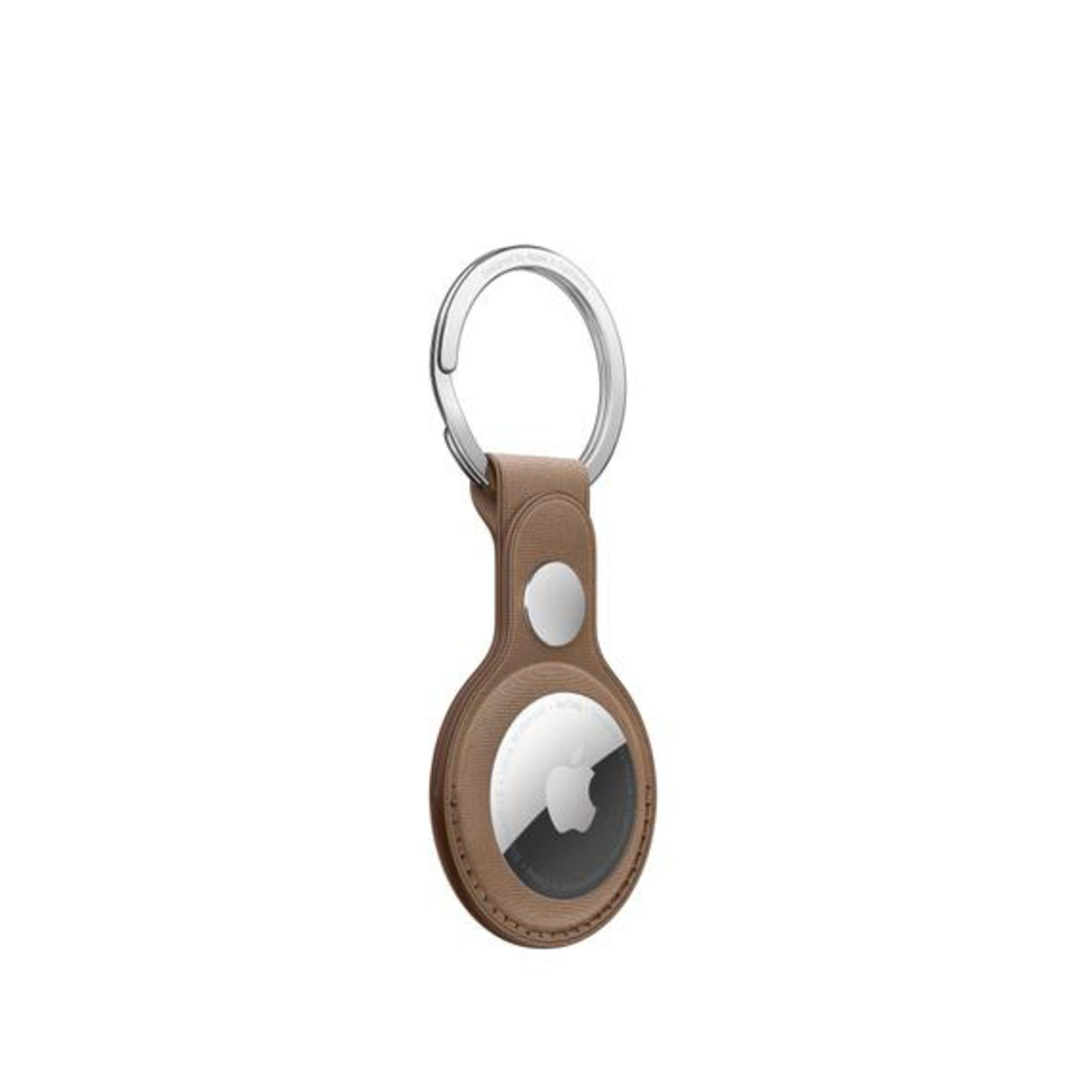 An Apple AirTag with a brown leather key ring attachment on white.