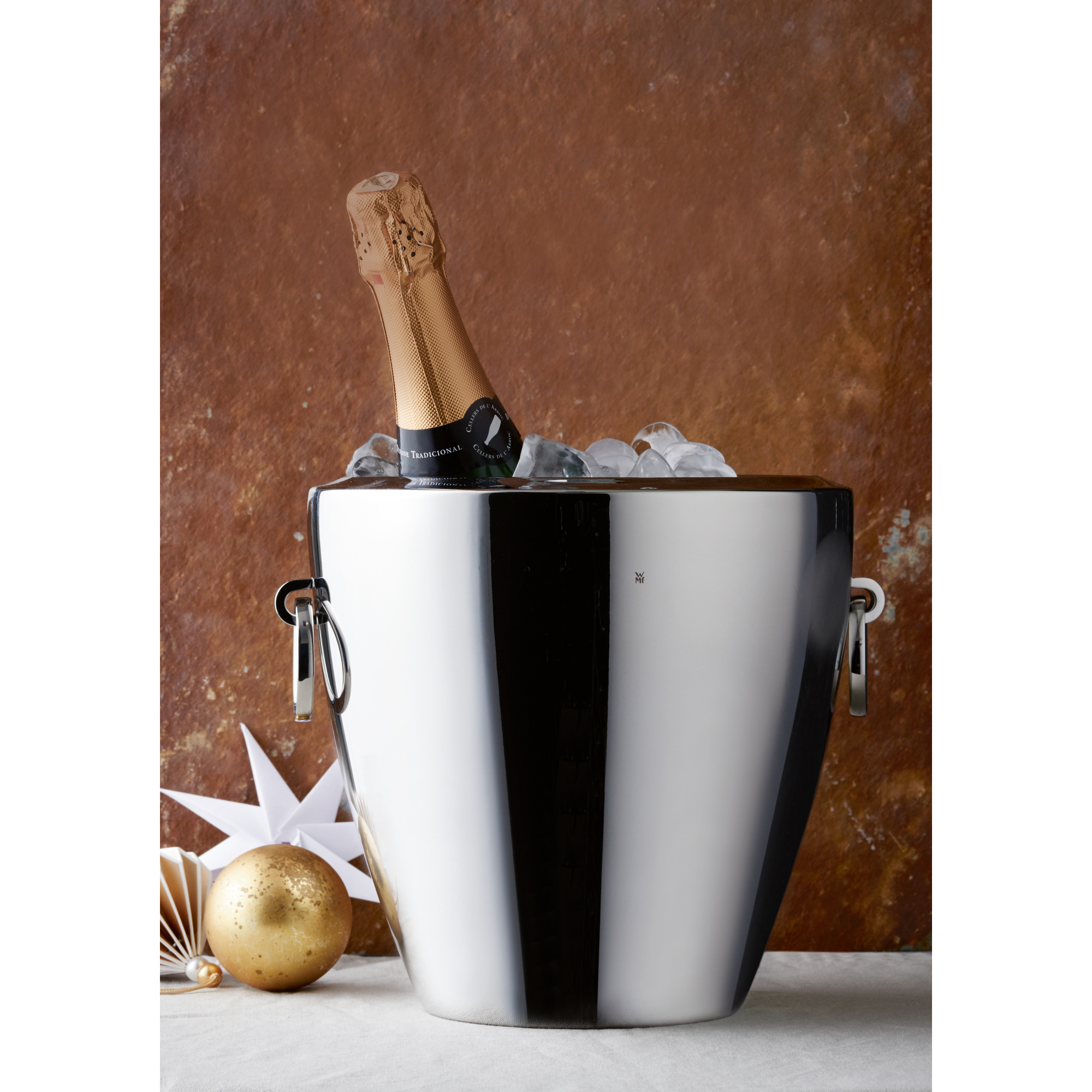 Eine Champagnerflasche in einem Eiskübel, mit Eiswürfeln und festlichem Hintergrund.